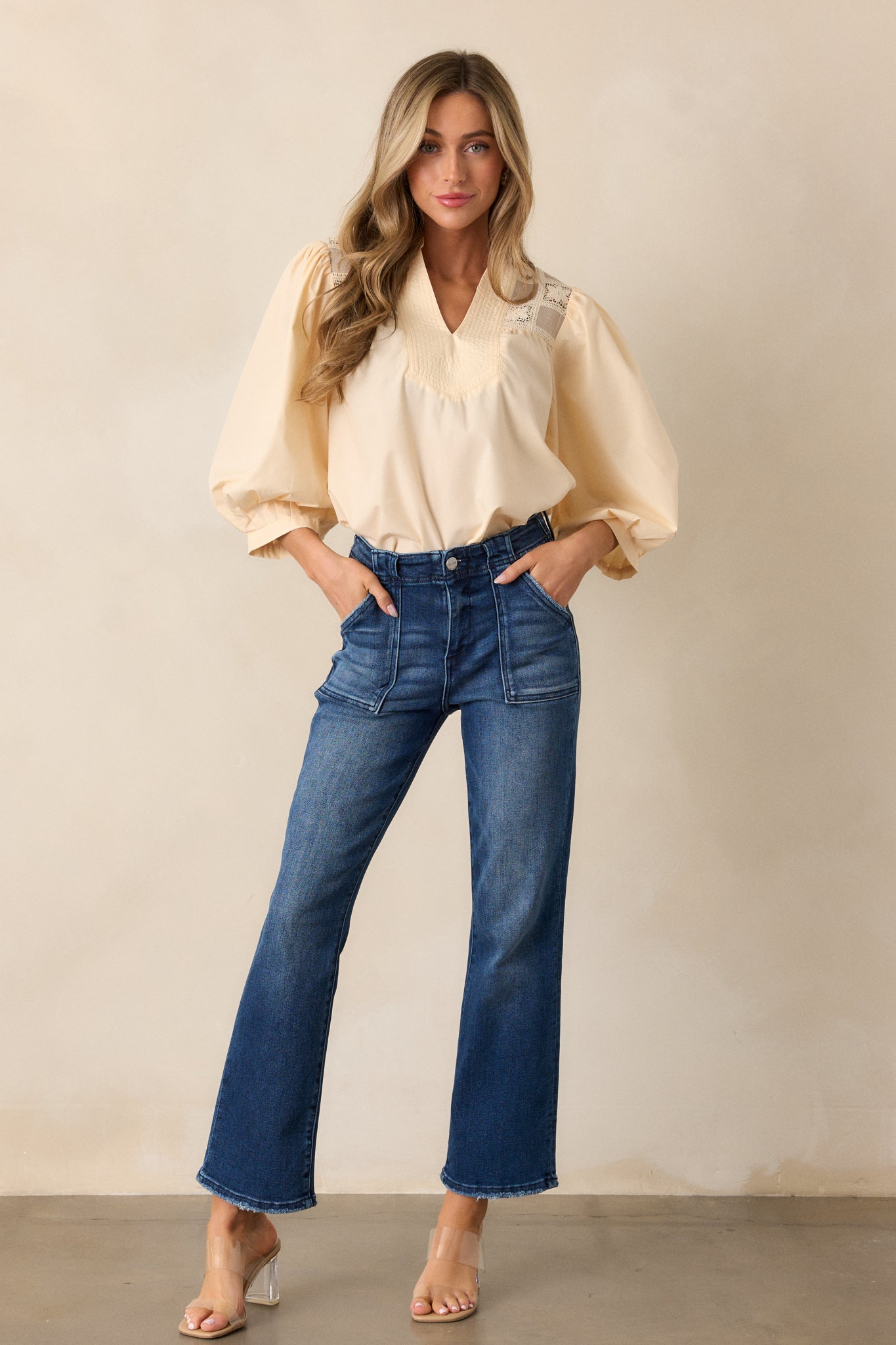 Almond-colored blouse with puff sleeves and a v-neckline, highlighting the checkered floral stitching detail along the shoulders and back.