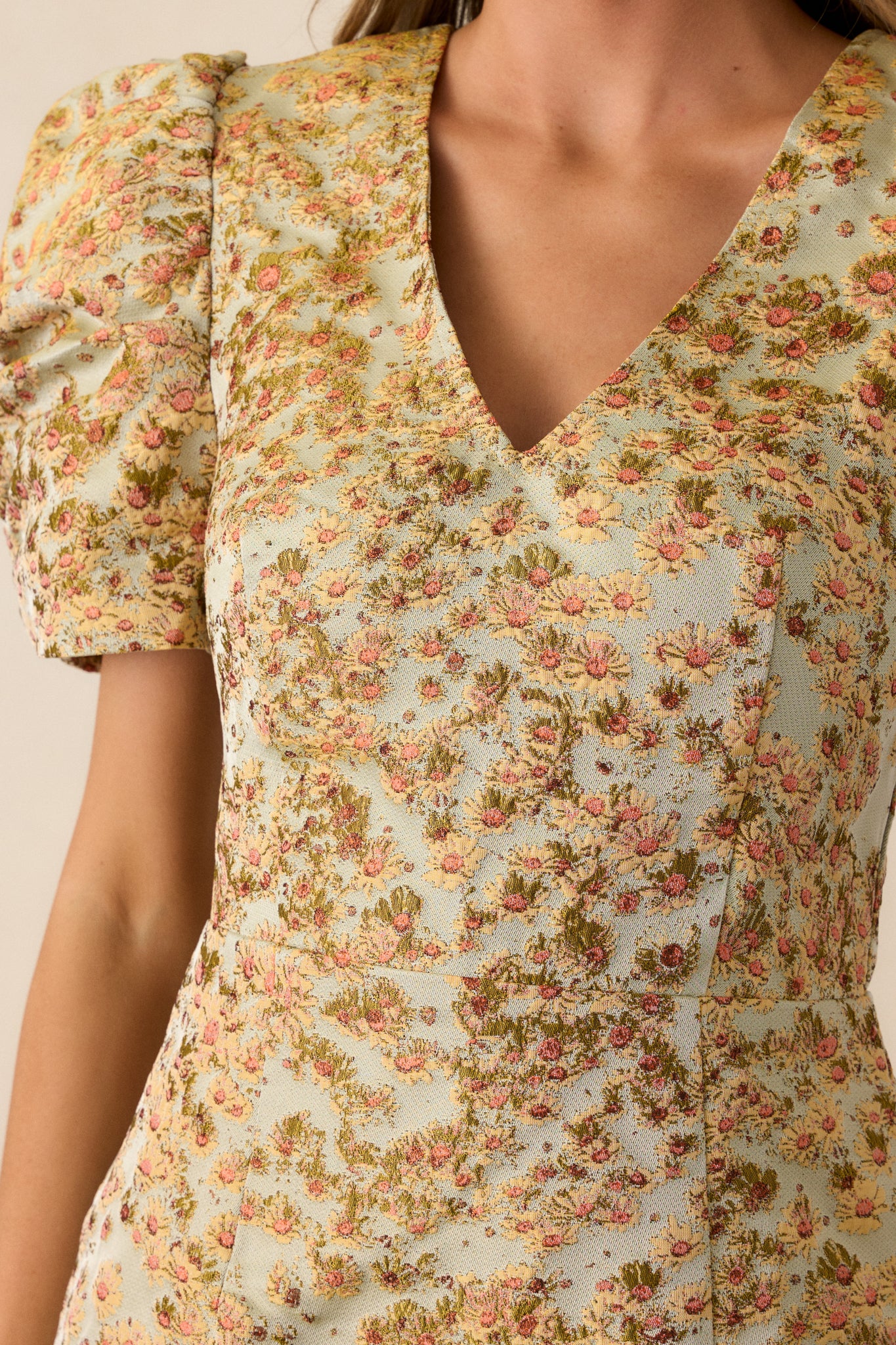 Close-up of the floral detailing on the honey dress, highlighting the intricate pattern that runs throughout the fitted design.