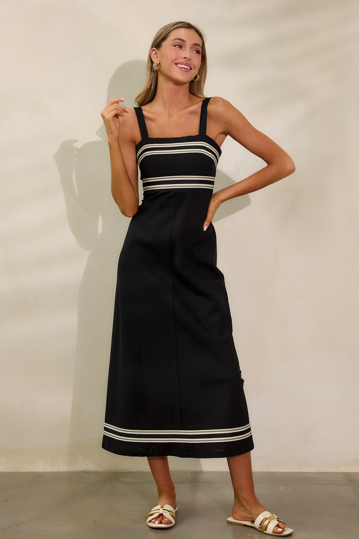 Another full body view of the black dress, highlighting the contrast detailing and the smocked back panel for a fitted silhouette.