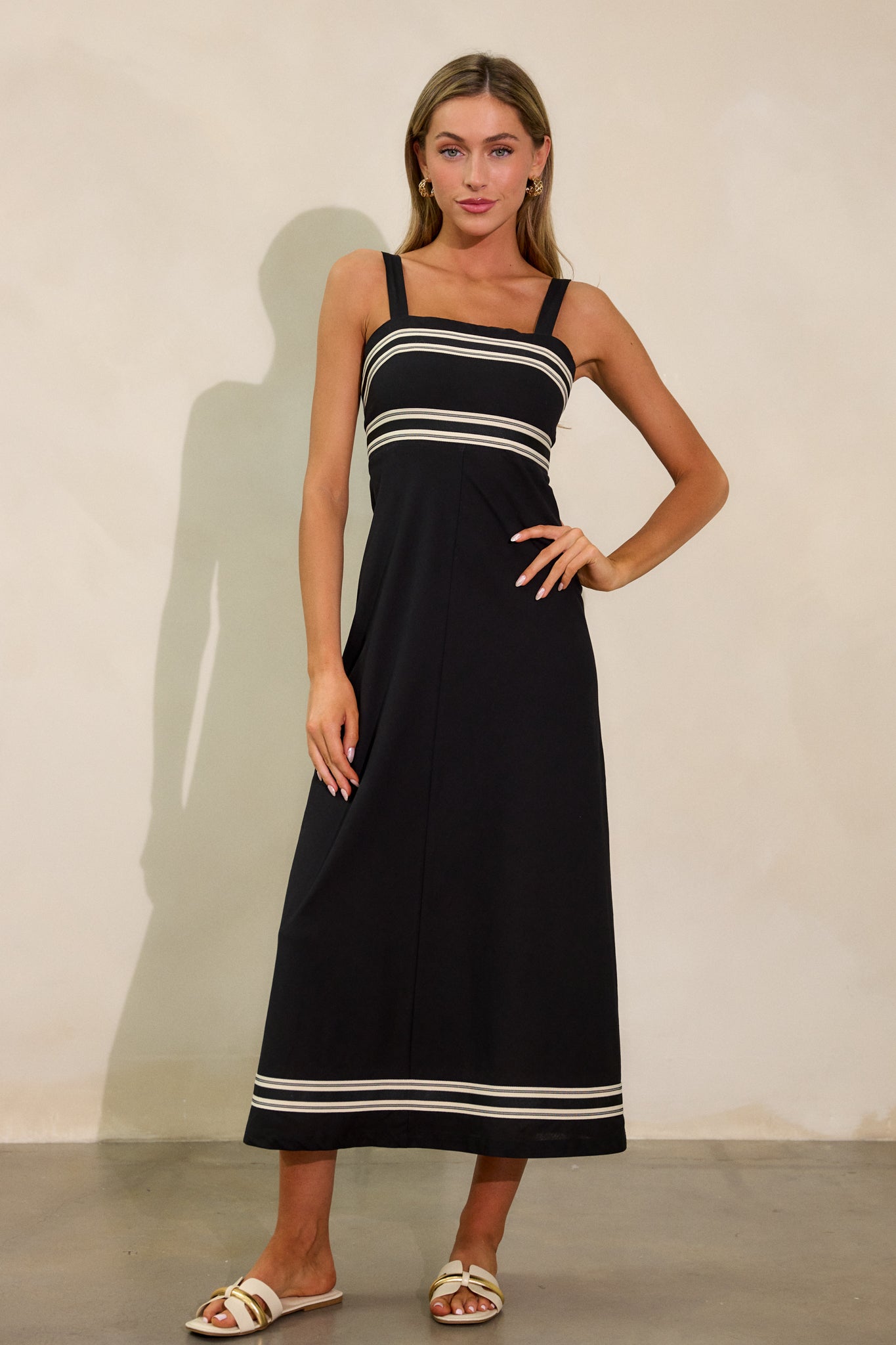 A full front view of the black dress, focusing on the structured look created by the contrast detailing and smocked back.