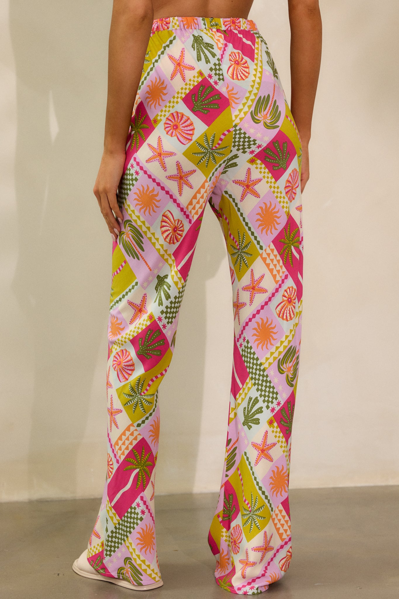 Back view of the pants, capturing the high waist cut and the continuation of the tropical pattern along the rear and legs.