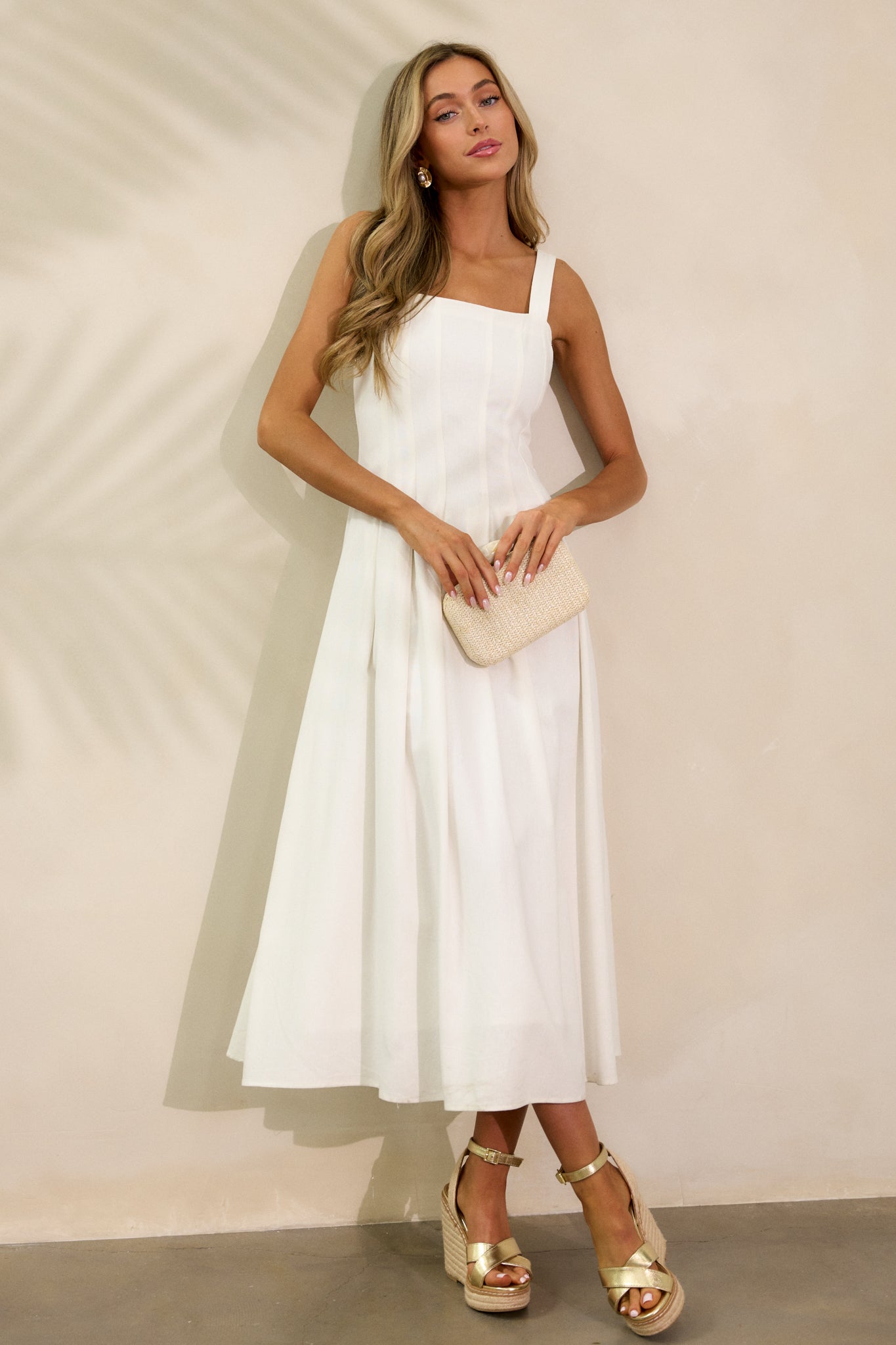 A front view of the ivory dress highlighting the square neckline and flowing silhouette. The discrete back zipper is barely noticeable, contributing to the clean, elegant look of the dress.