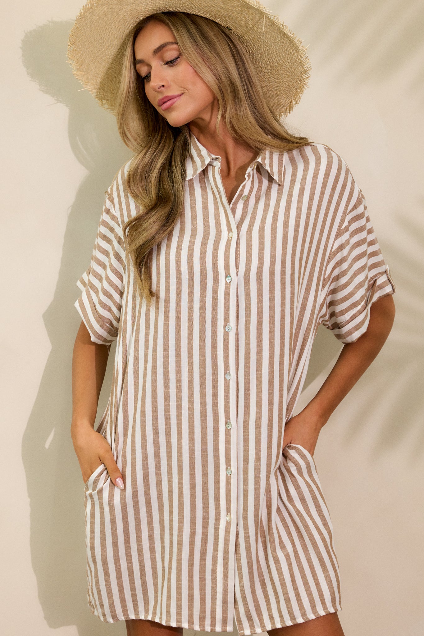 Cropped view of the front of the dress, showing the collared neckline, button details, and short sleeves with stripe pattern.