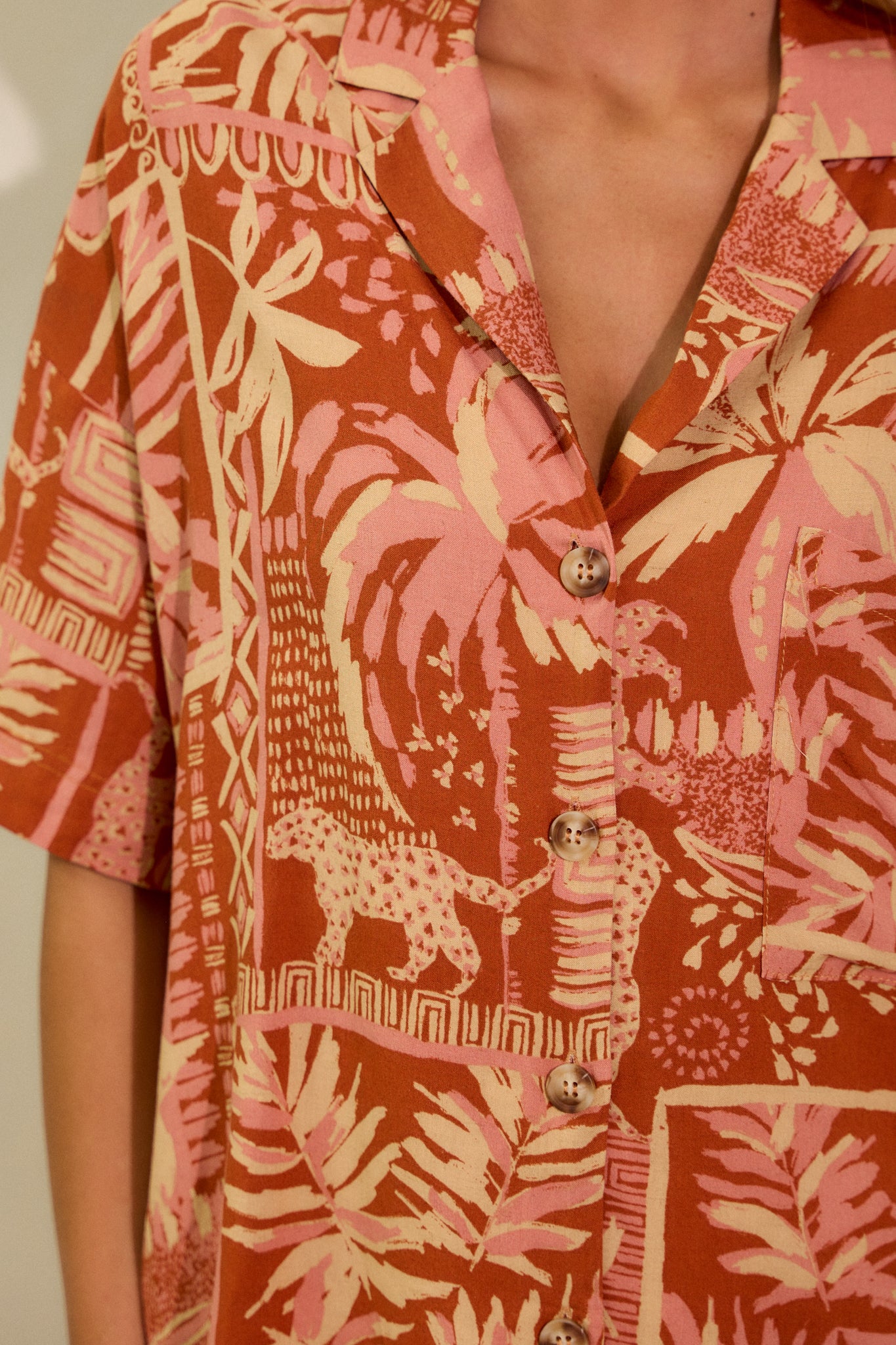 A detailed close-up of the sienna rose top, showcasing the notched lapel collared v-neckline, the button-down front, and the functional breast pocket. The textured fabric and design details are visible.