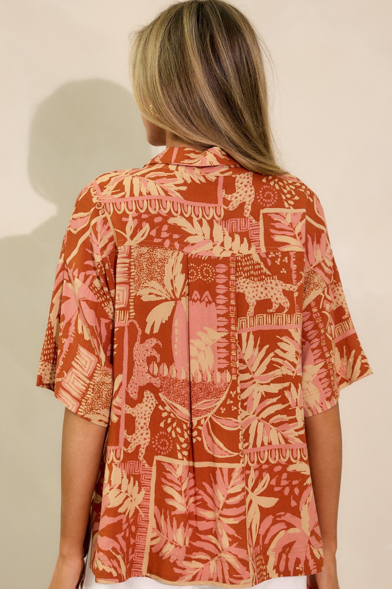 A back view of the sienna rose top, focusing on the relaxed fit and split hemline. The back design complements the front, with the short sleeves completing the overall silhouette.