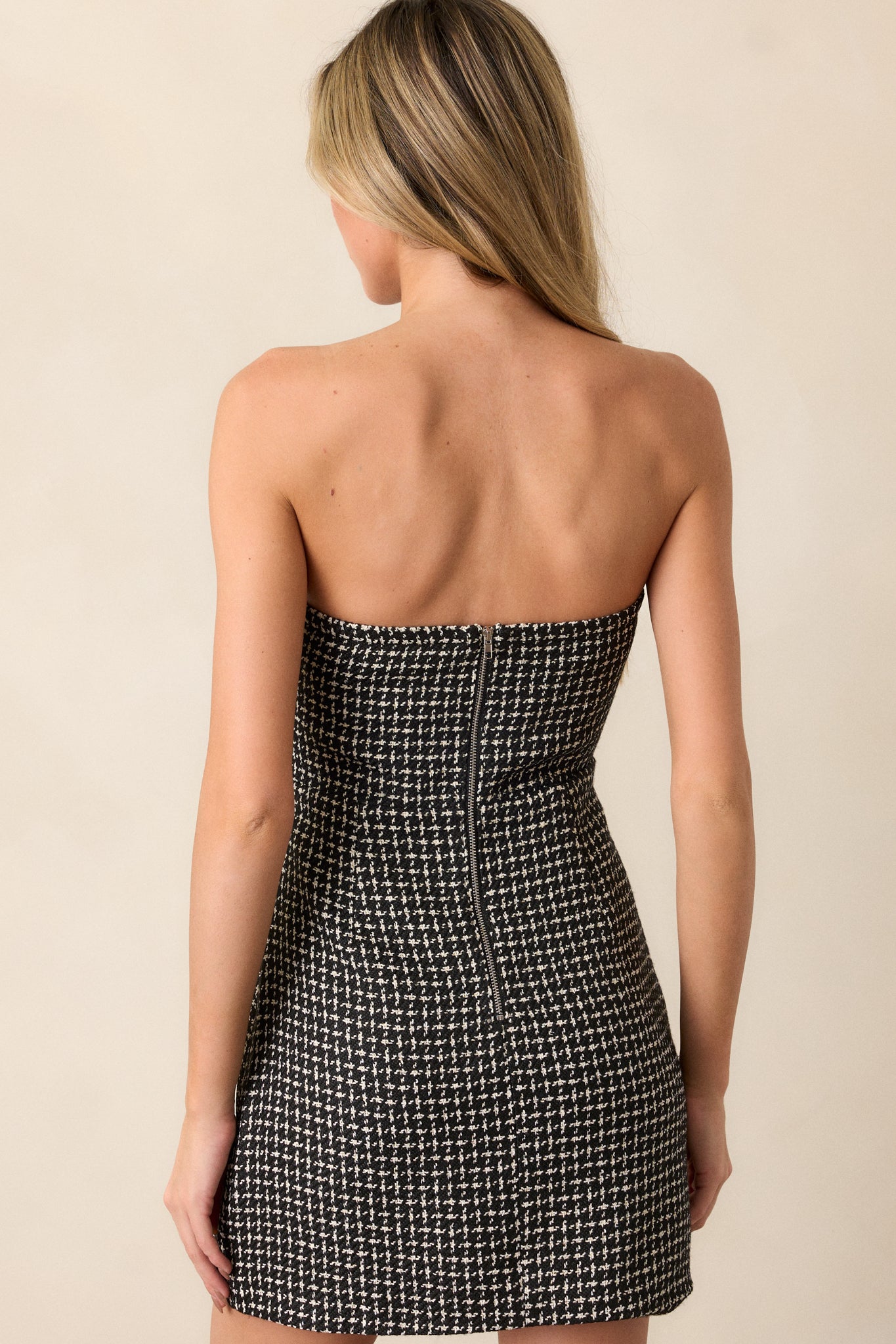 View of the back of the dress, featuring the discrete back zipper and the clean, strapless design from behind.