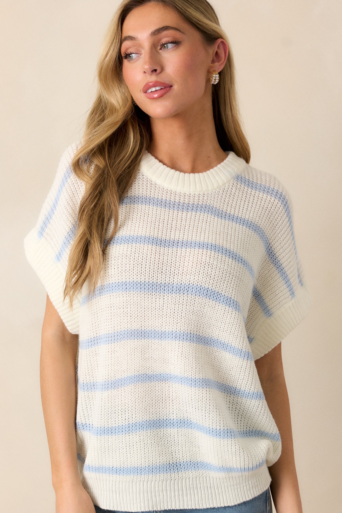 A cropped shot showing the relaxed fit of the top, with a focus on the ribbed bottom hem and short sleeves. The striped pattern runs horizontally across the body.