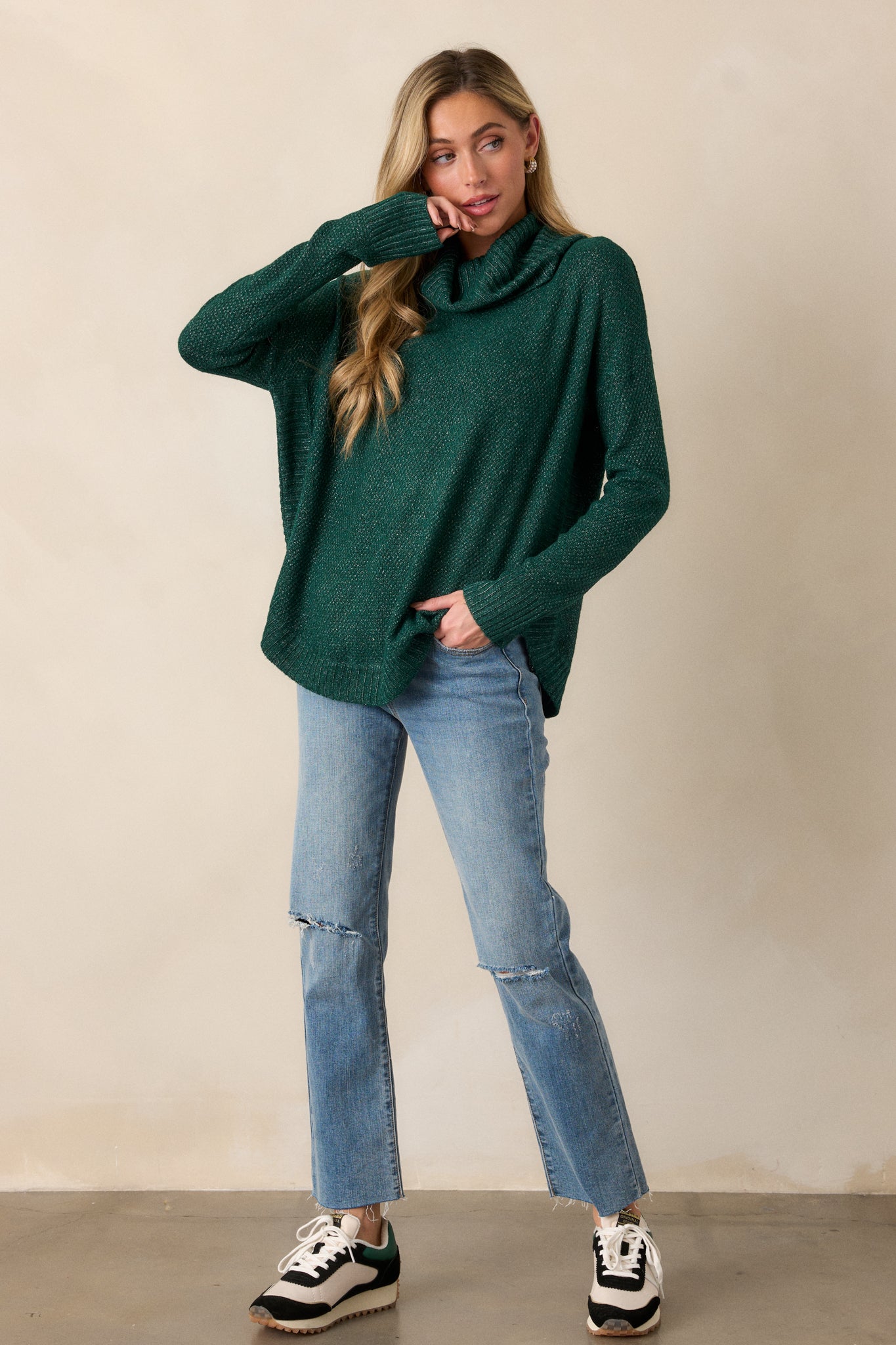 Full-body shot of the hunter green sweater highlighting the cowl turtleneck and relaxed fit with speckled detailing.