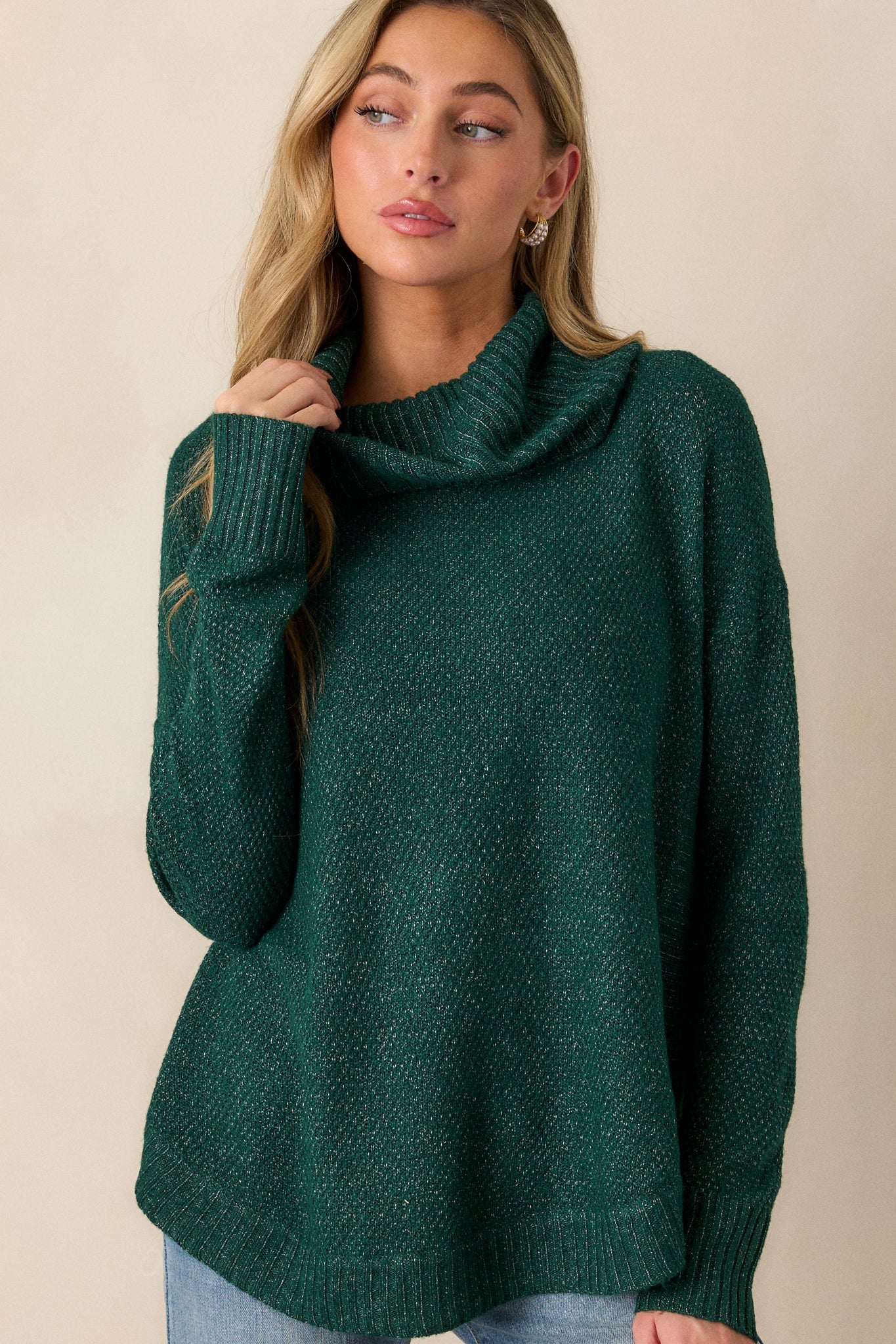 Close-up view showing the scooped hemline and speckled coloring on the hunter green sweater.