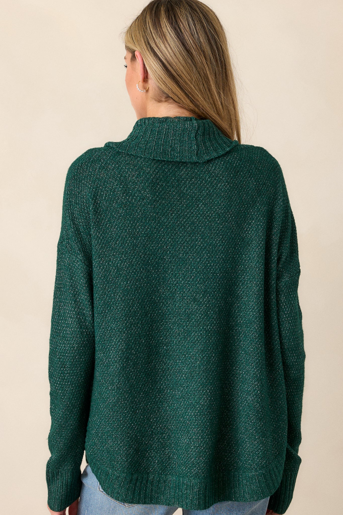 Back view of the hunter green sweater featuring the scooped hemline and speckled knit design.