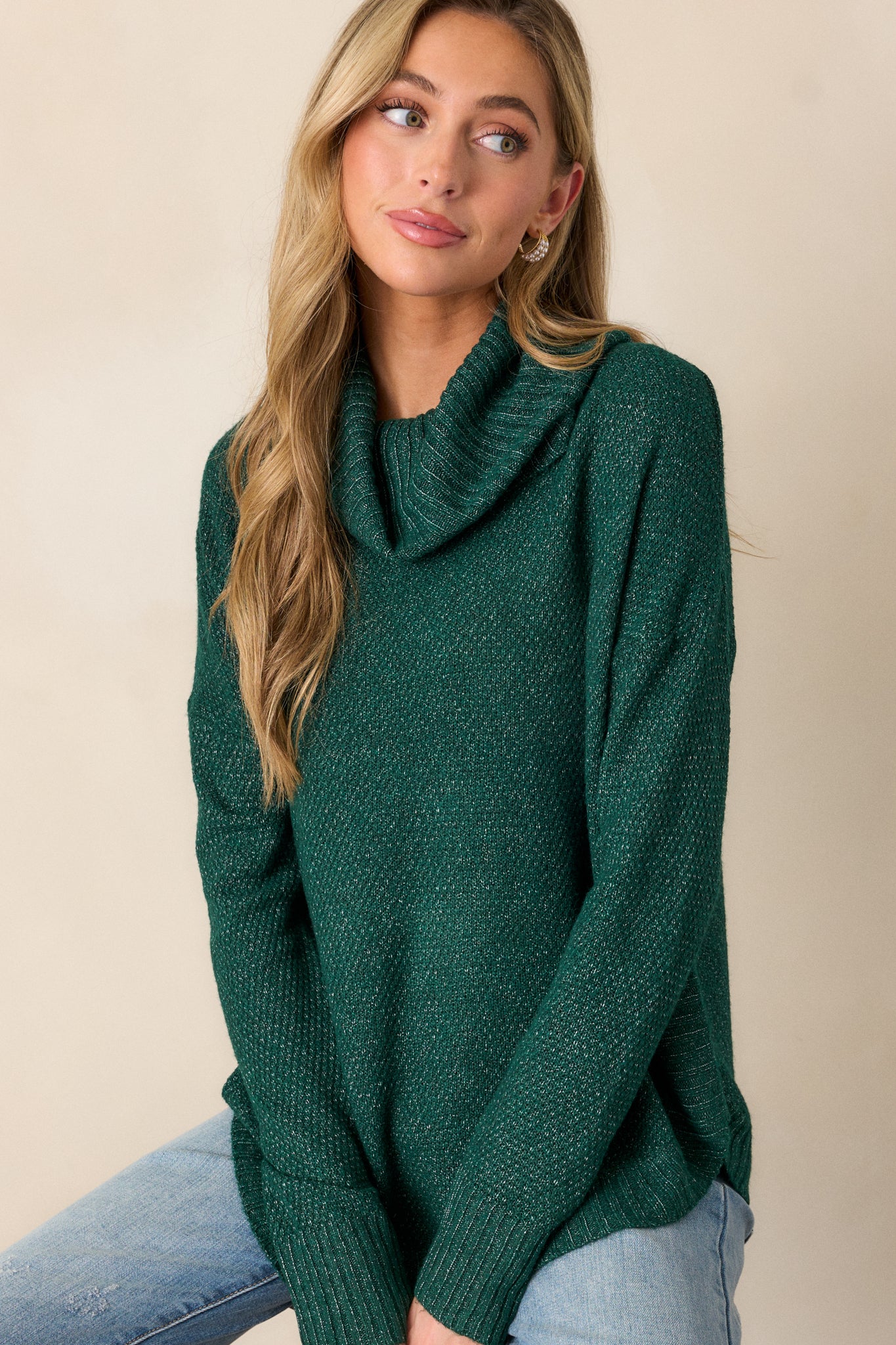 Cropped image focusing on the cowl turtleneck and speckled texture of the hunter green sweater.