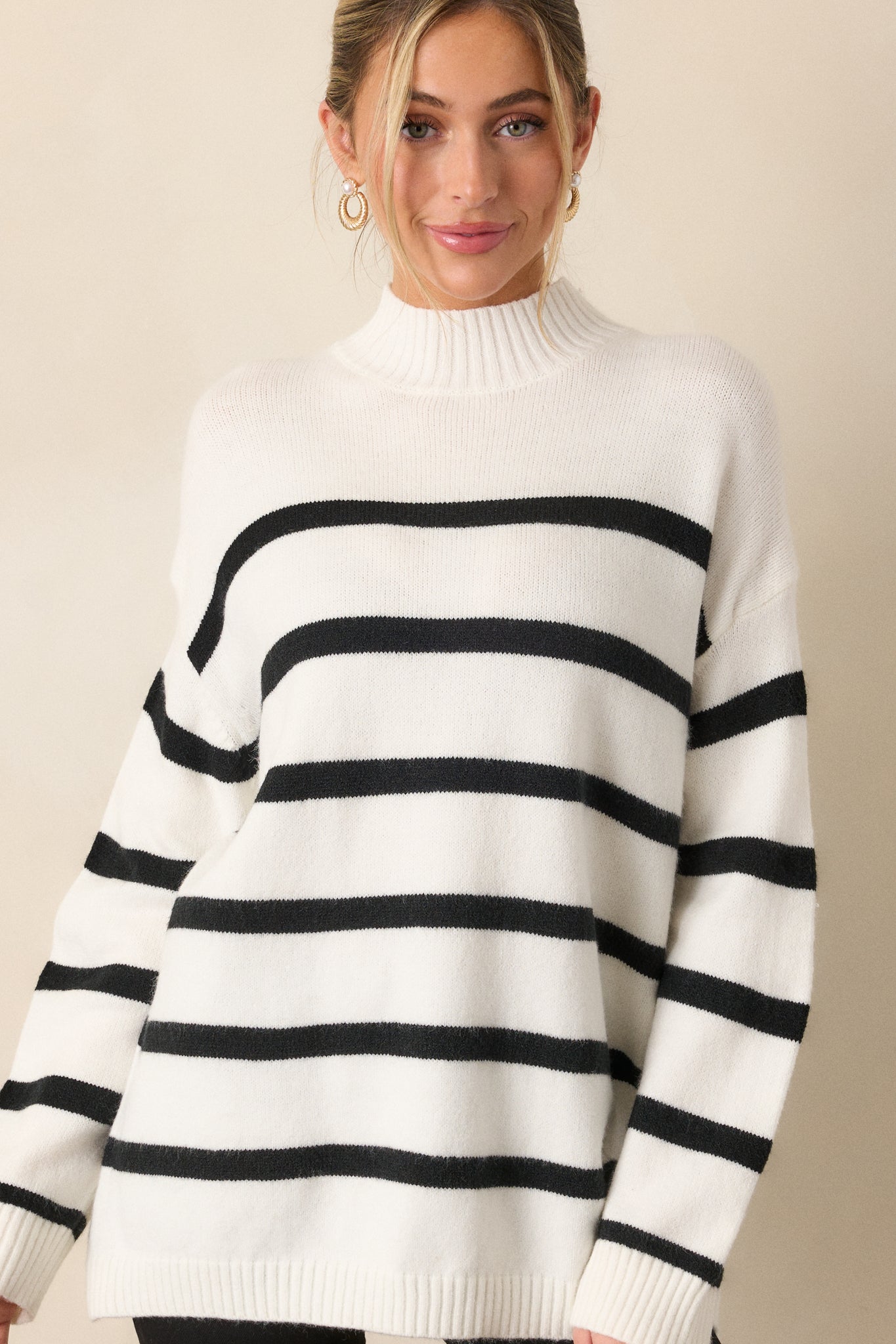 Front angle showing the relaxed, oversized silhouette of the sweater with ribbed hems and long sleeves.