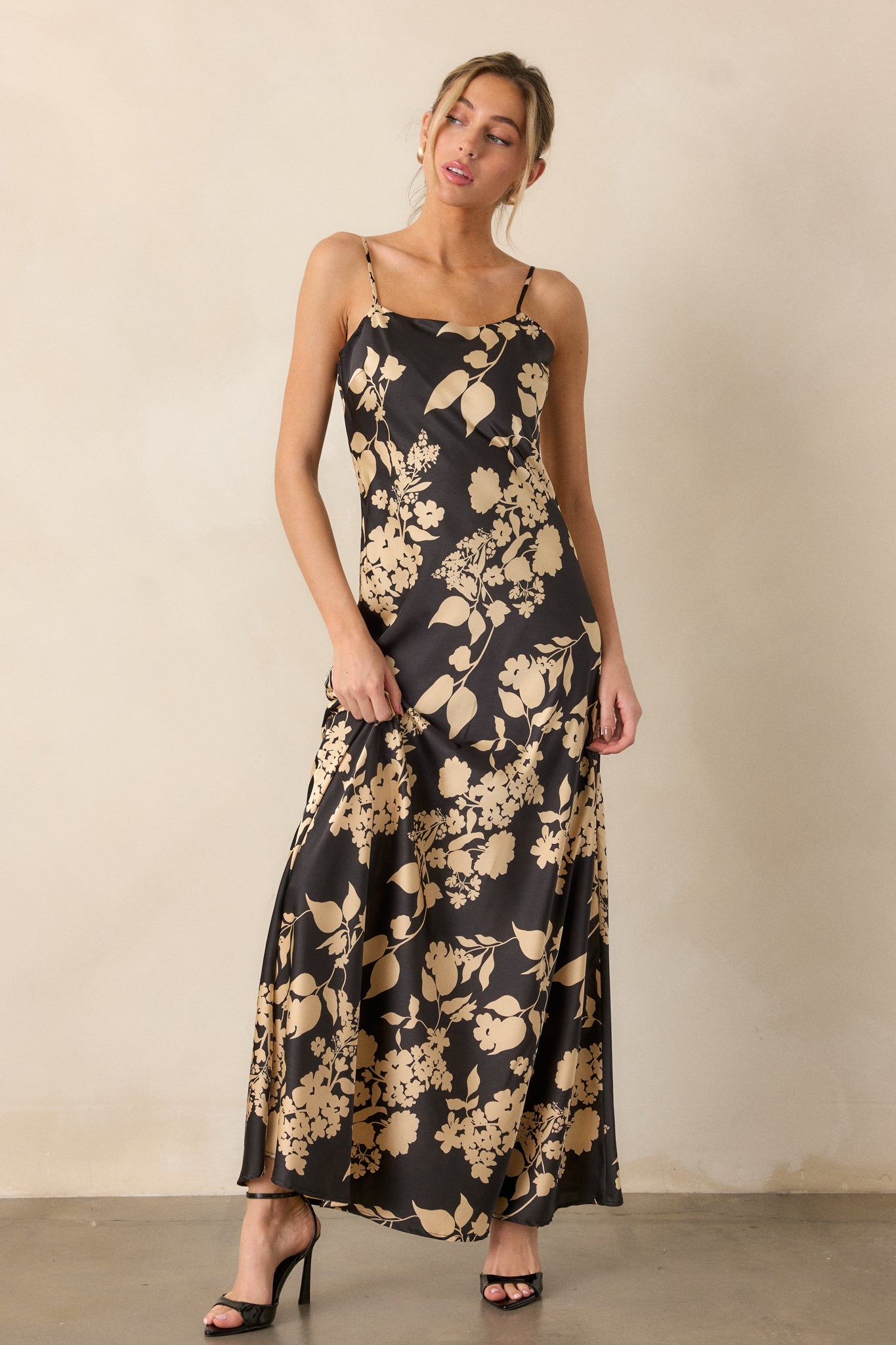 Focus on the silhouette of the dress, emphasizing the fitted bodice, sleeveless design, and the dramatic floral pattern against the black fabric.