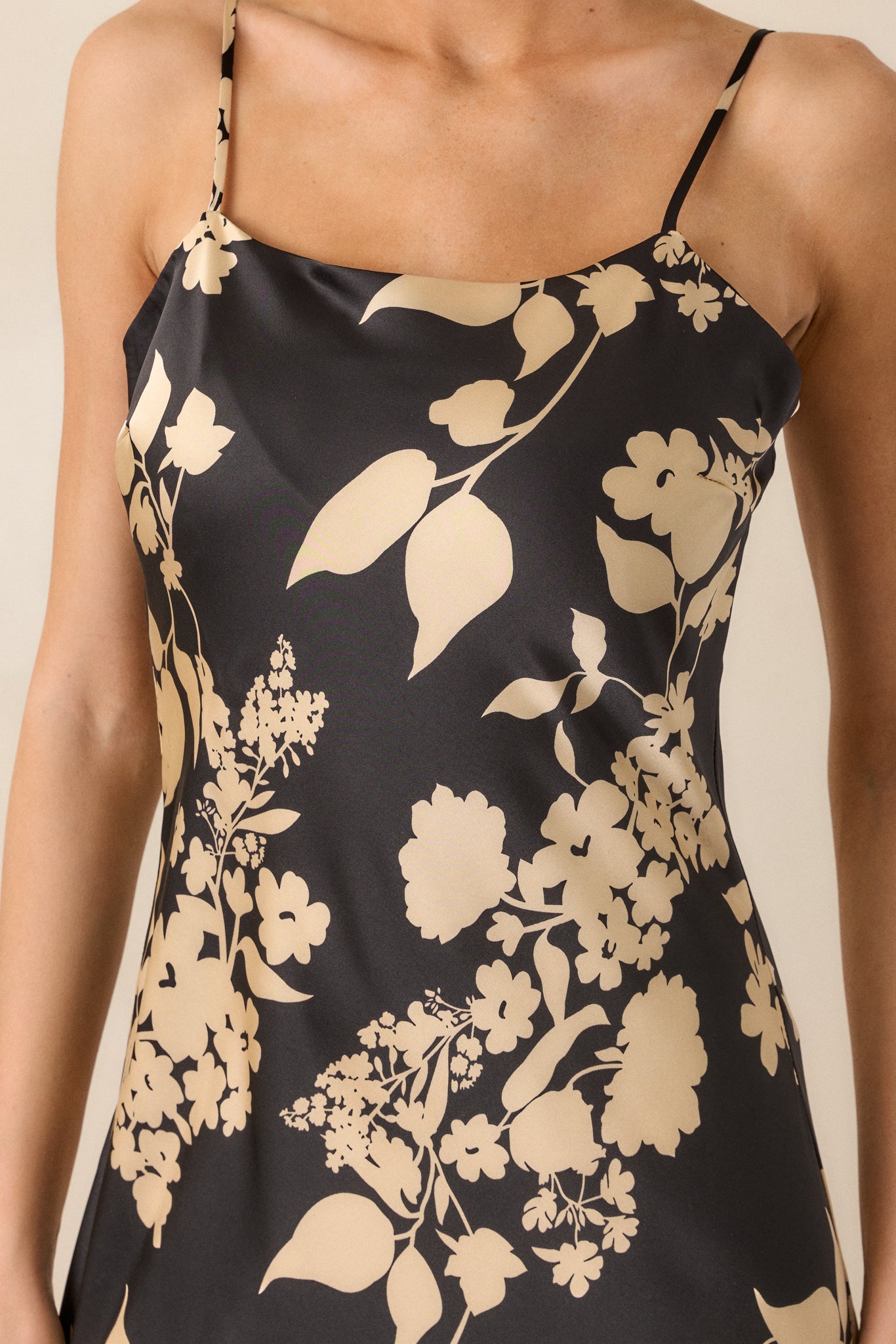 A zoomed-in shot of the floral detailing, highlighting the gold accents and how they contrast with the black fabric near the neckline.