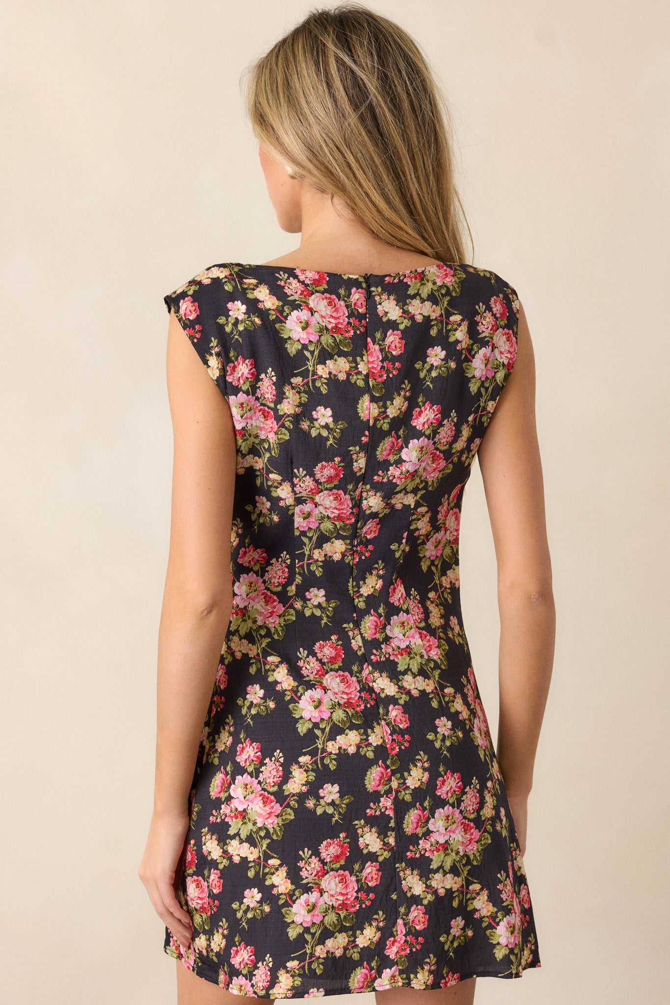 Back view of the black midi dress, displaying the discrete zipper and overall silhouette with cap sleeves from behind.