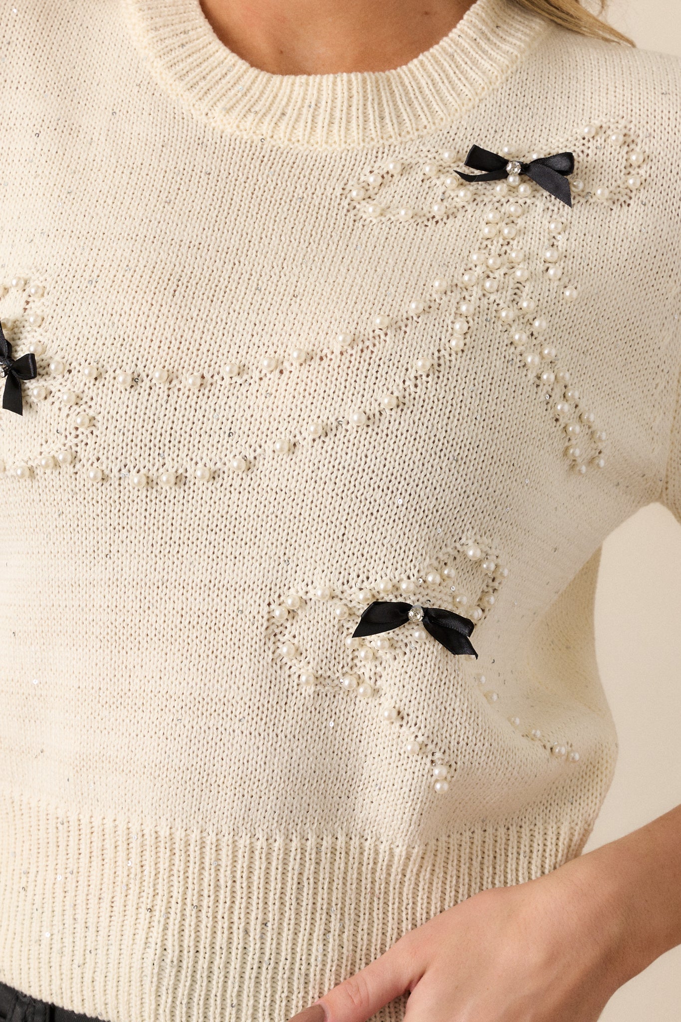 A zoomed-in shot of the silver sequins dispersed throughout the knit fabric, emphasizing their subtle shimmer and texture.