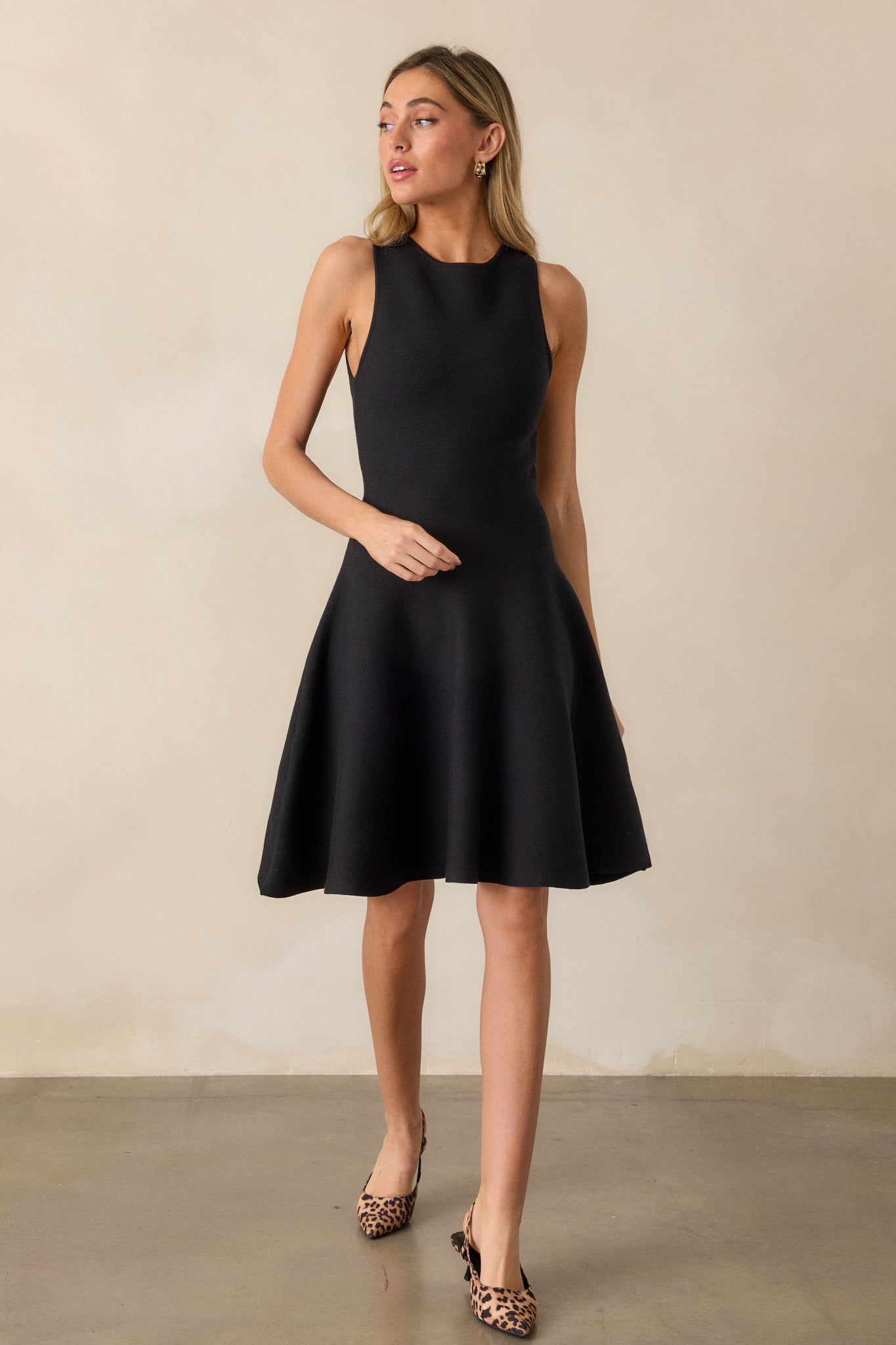 Full-length shot of the black dress, showcasing the rounded neckline, drop waist, and flared skirt.