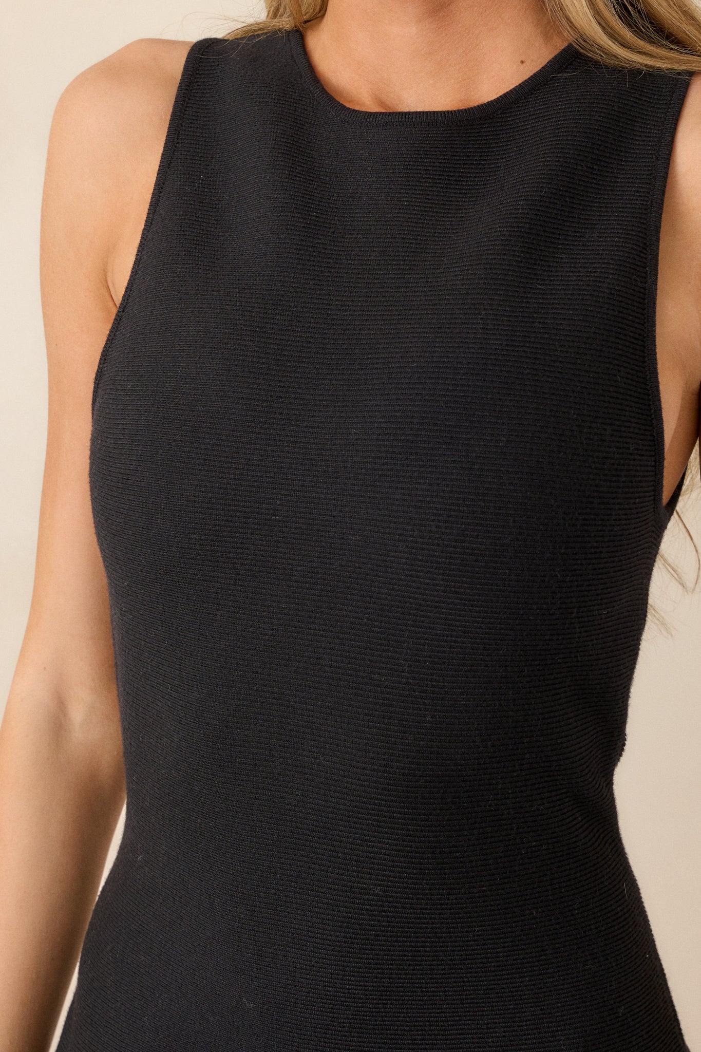 Close-up of the dress fabric and detailing, emphasizing the rounded neckline and fine stitching at the edge.