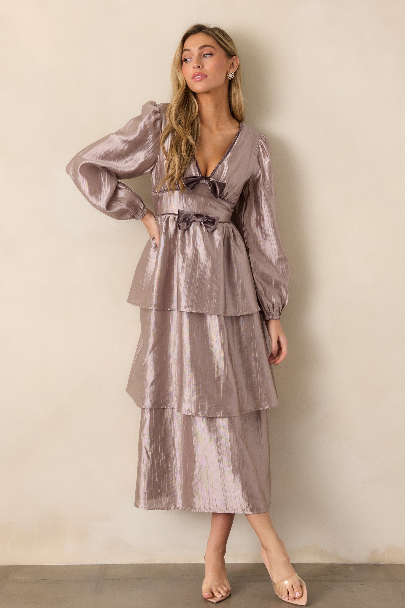 A full view of the metallic grey dress, showcasing the v-neckline, tiered midi-length skirt, and long lantern sleeves with elastic wrist cuffs.