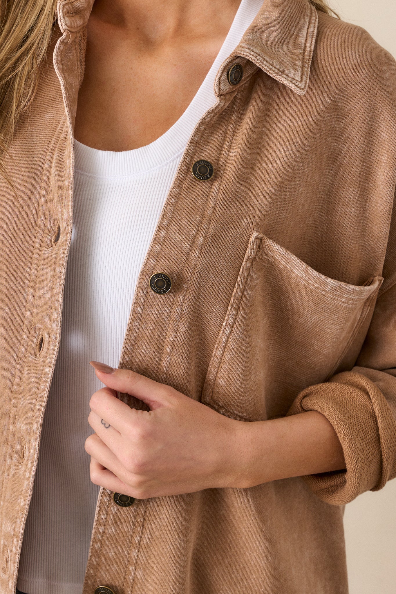 Close-up of the jacket focusing on the collared neckline, one of the functional chest pockets, and the full button front.