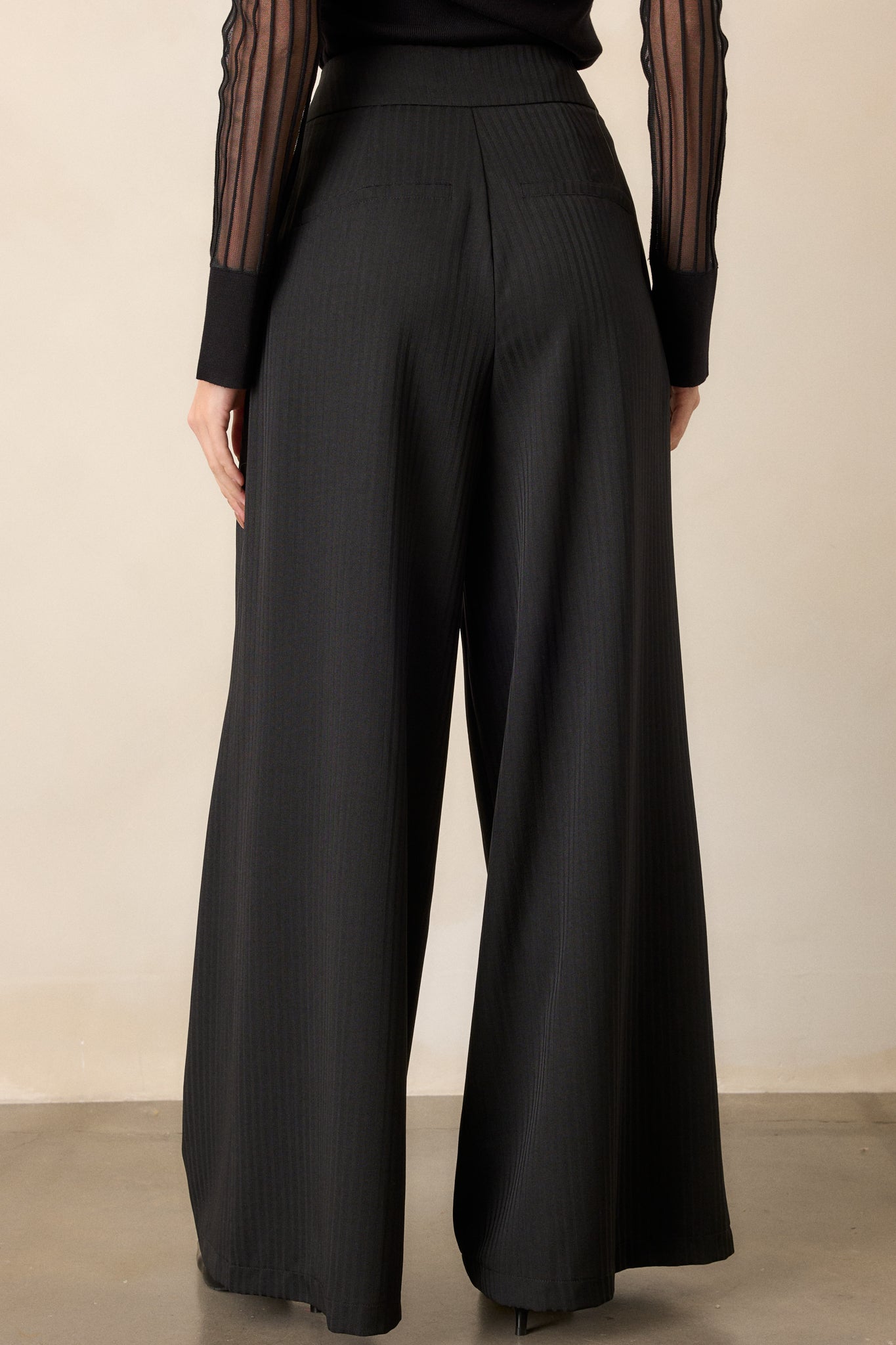 Back view of the trousers, showing the smooth finish and wide-leg cut, with the gray stripe pattern subtly visible.