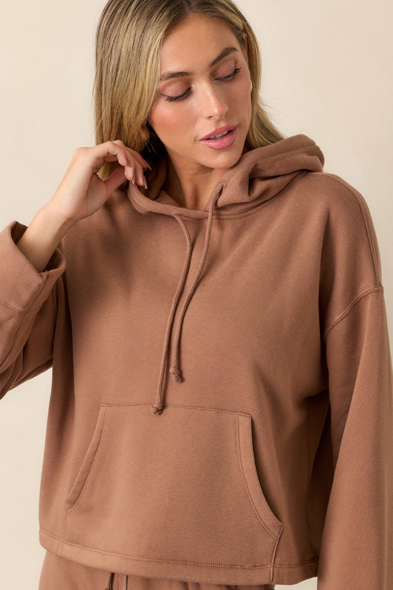 Closer view of the sweatshirt’s kangaroo pocket and the bottom portion of the loose sleeves, capturing its relaxed style.