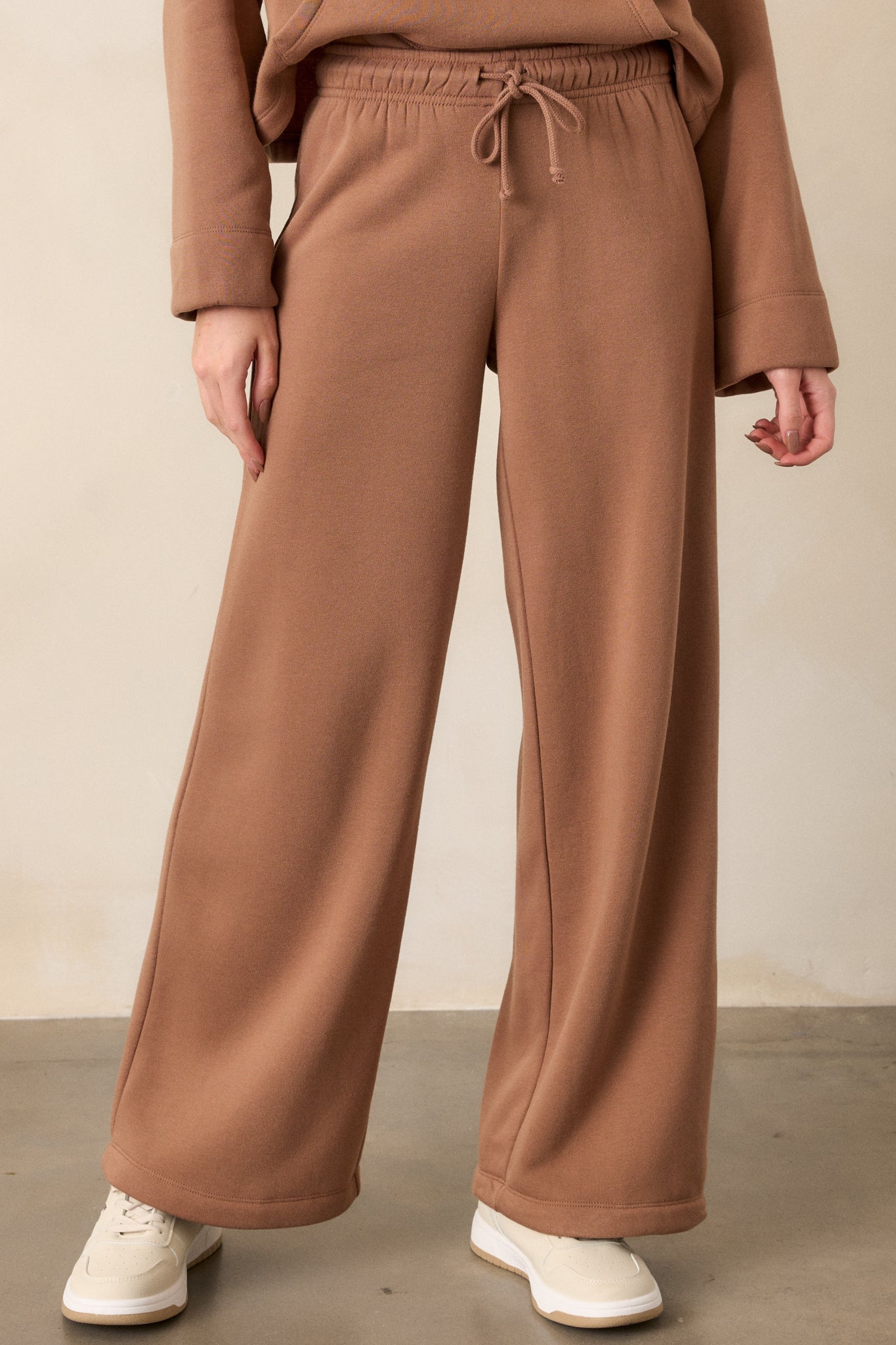 A cropped view of the wide-leg fit, focusing on the flowing, loose cut of the brown fabric.