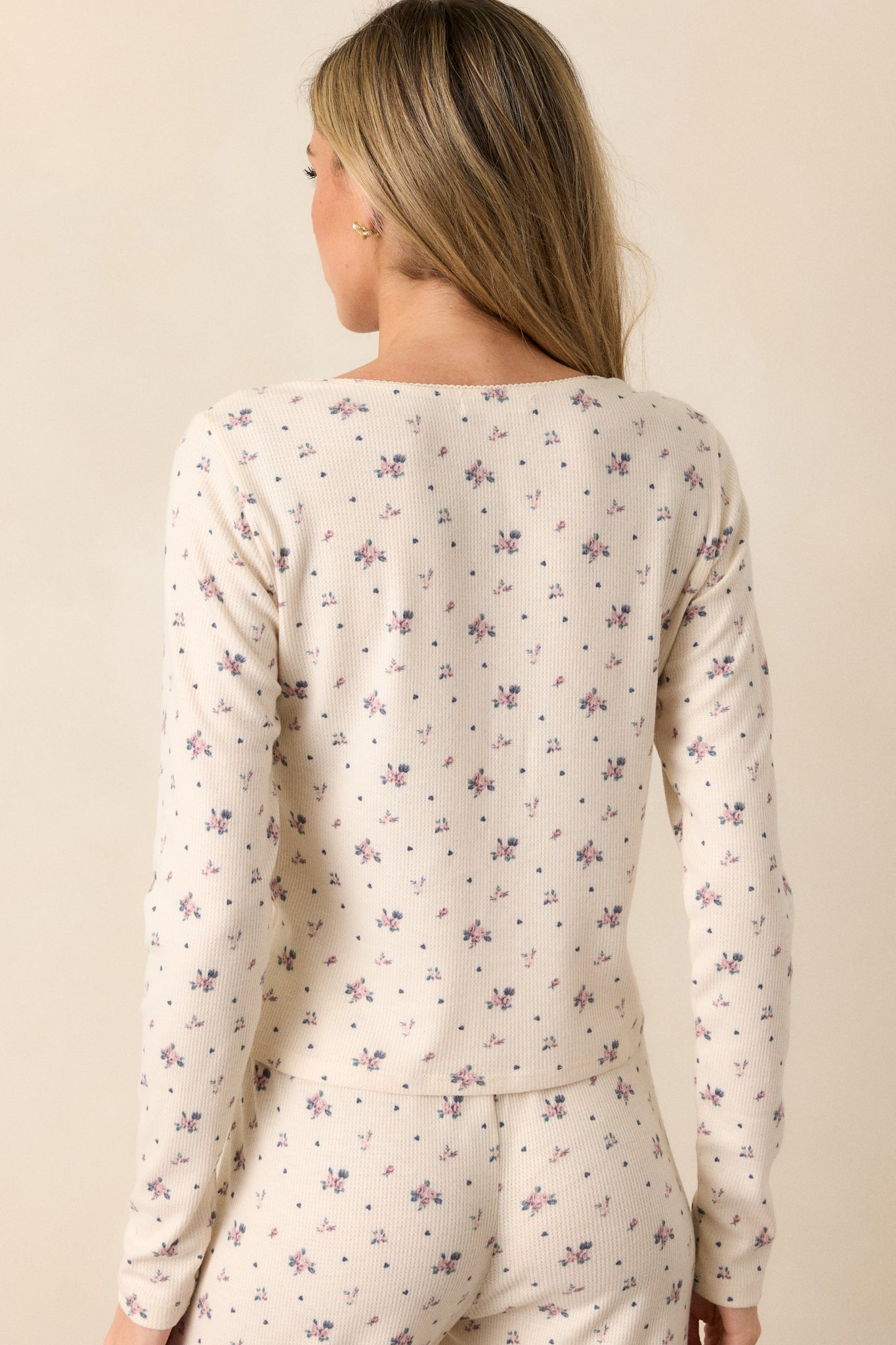 Back view of the ivory top, displaying long sleeves and the ditsy rose print on the fabric without buttons.