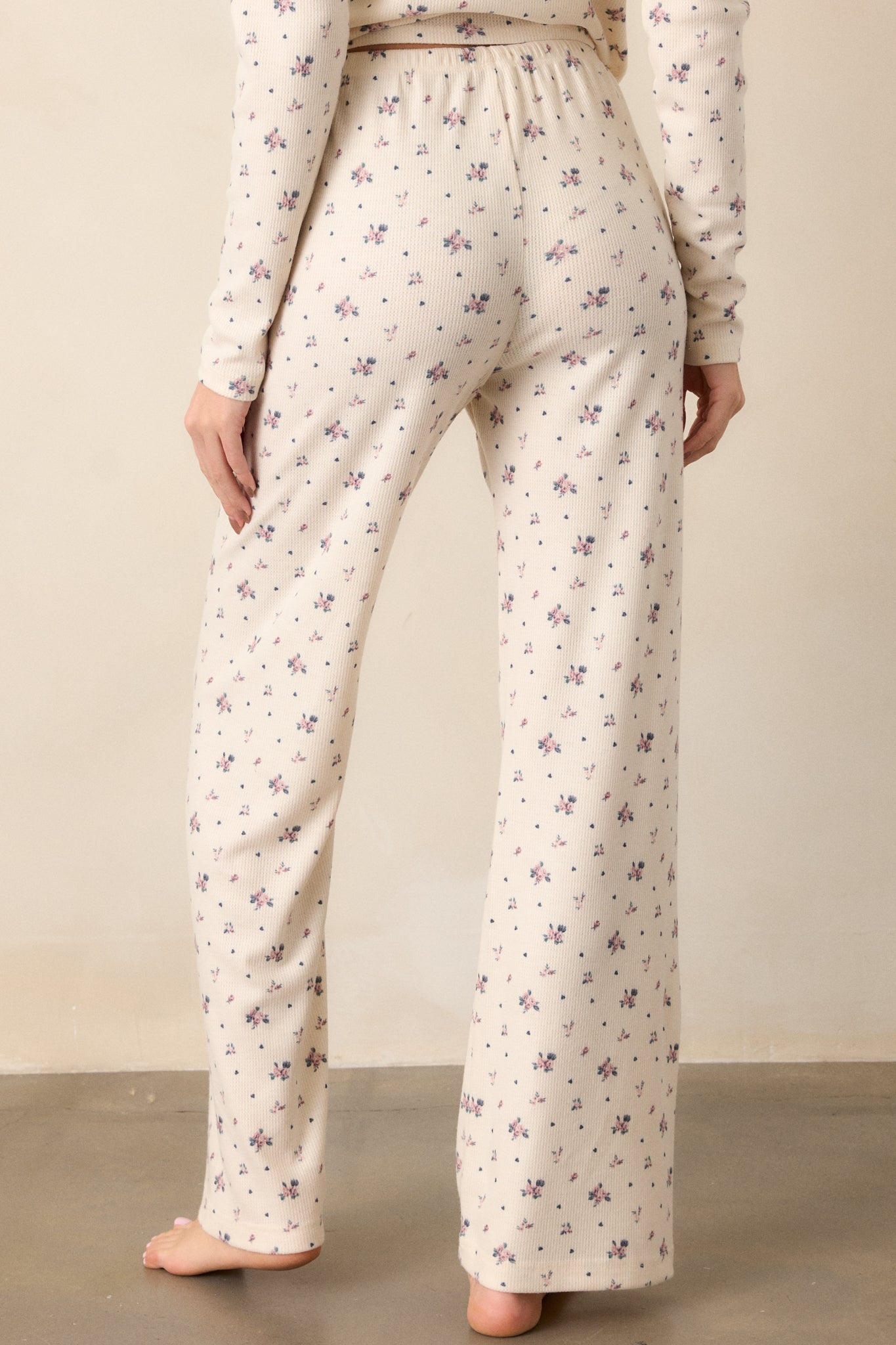 Back view of the ivory lounge pants, displaying the mid-rise fit and the clean lines of the full-length straight leg cut from behind.