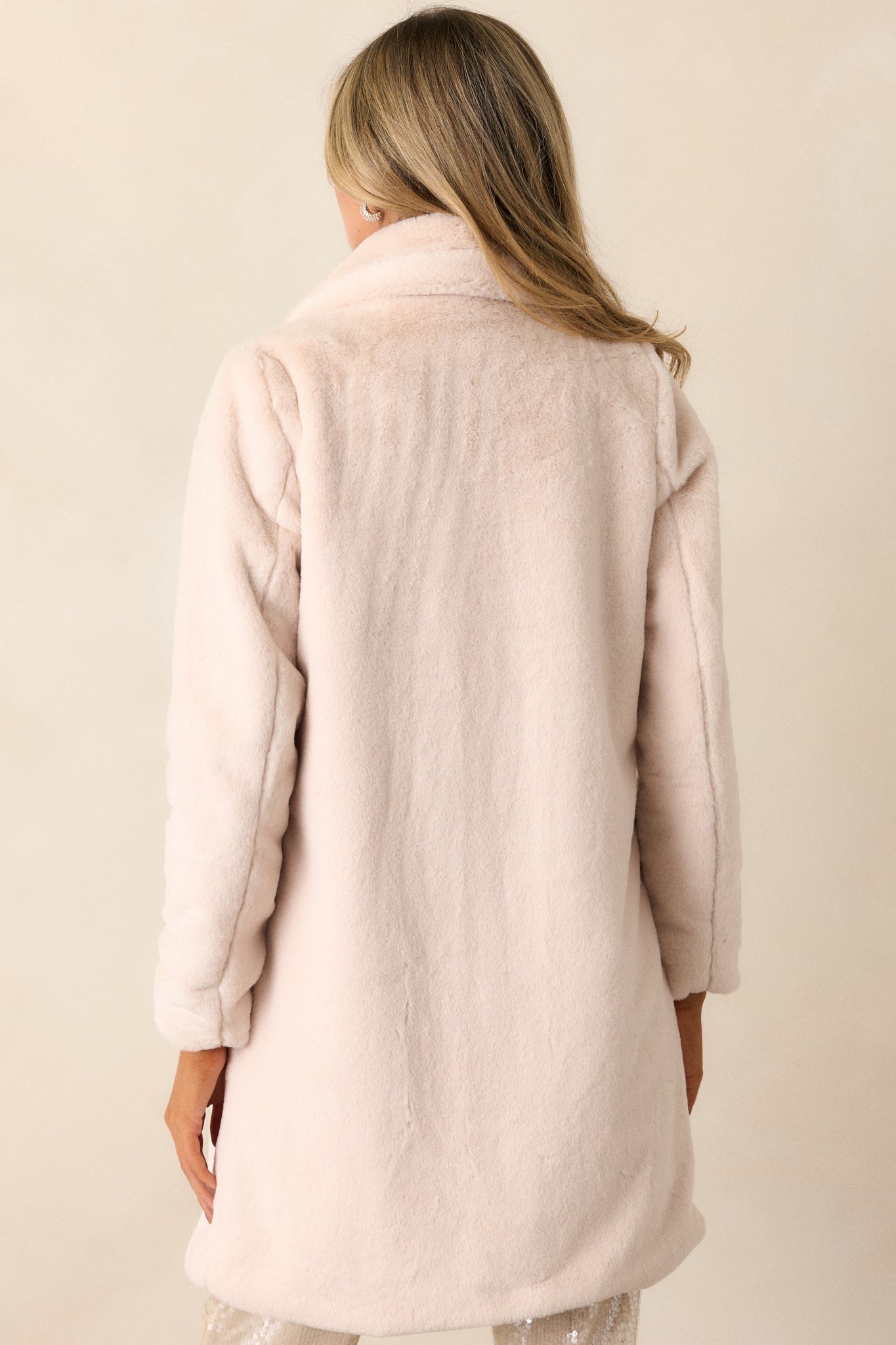 View of the back of the coat, featuring the continuous faux fur exterior and the long, smooth silhouette down to the hem.