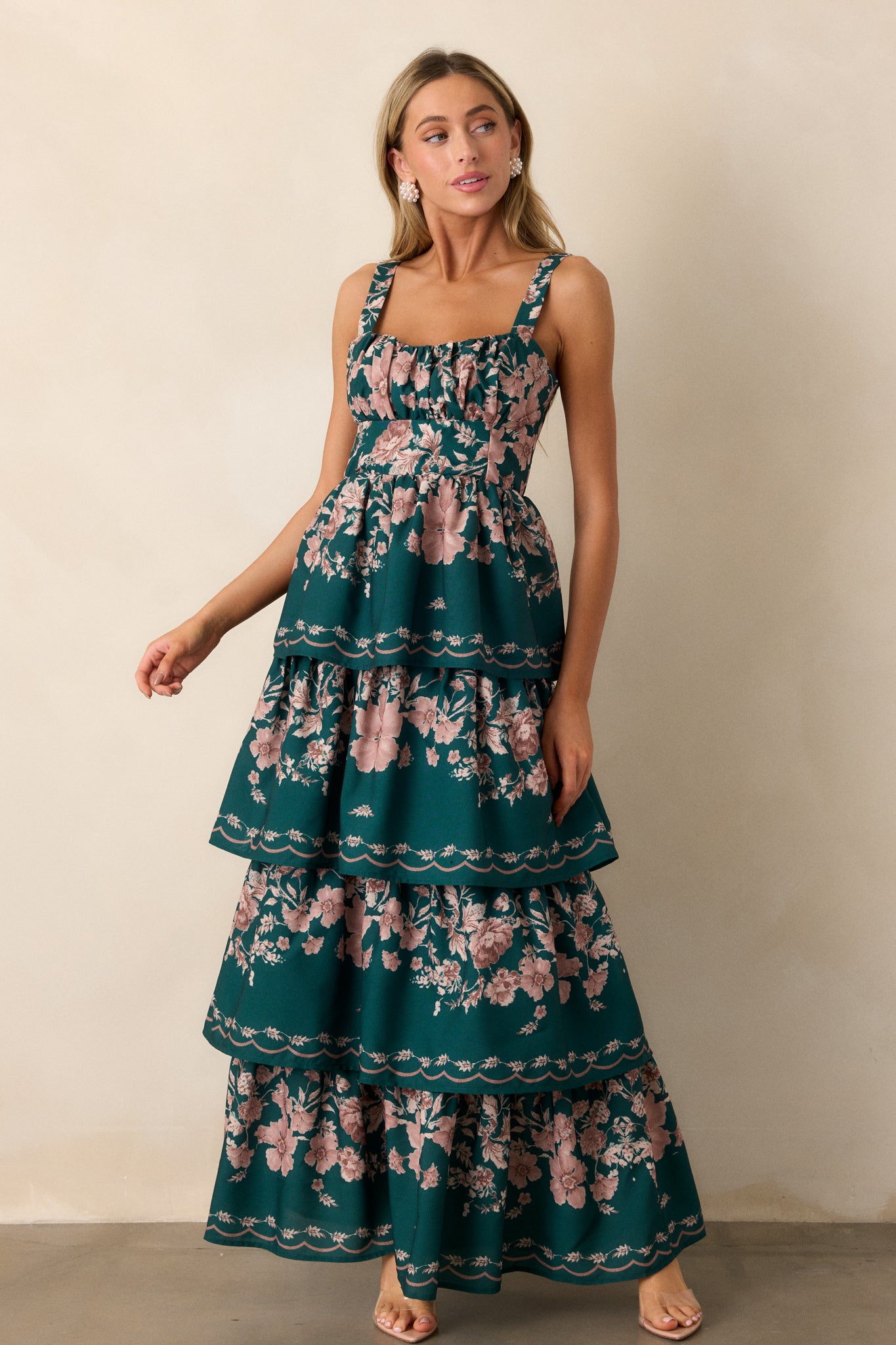 Front view of a green-colored dress featuring four flowy tiers, adjustable straps, and a back functional zipper.