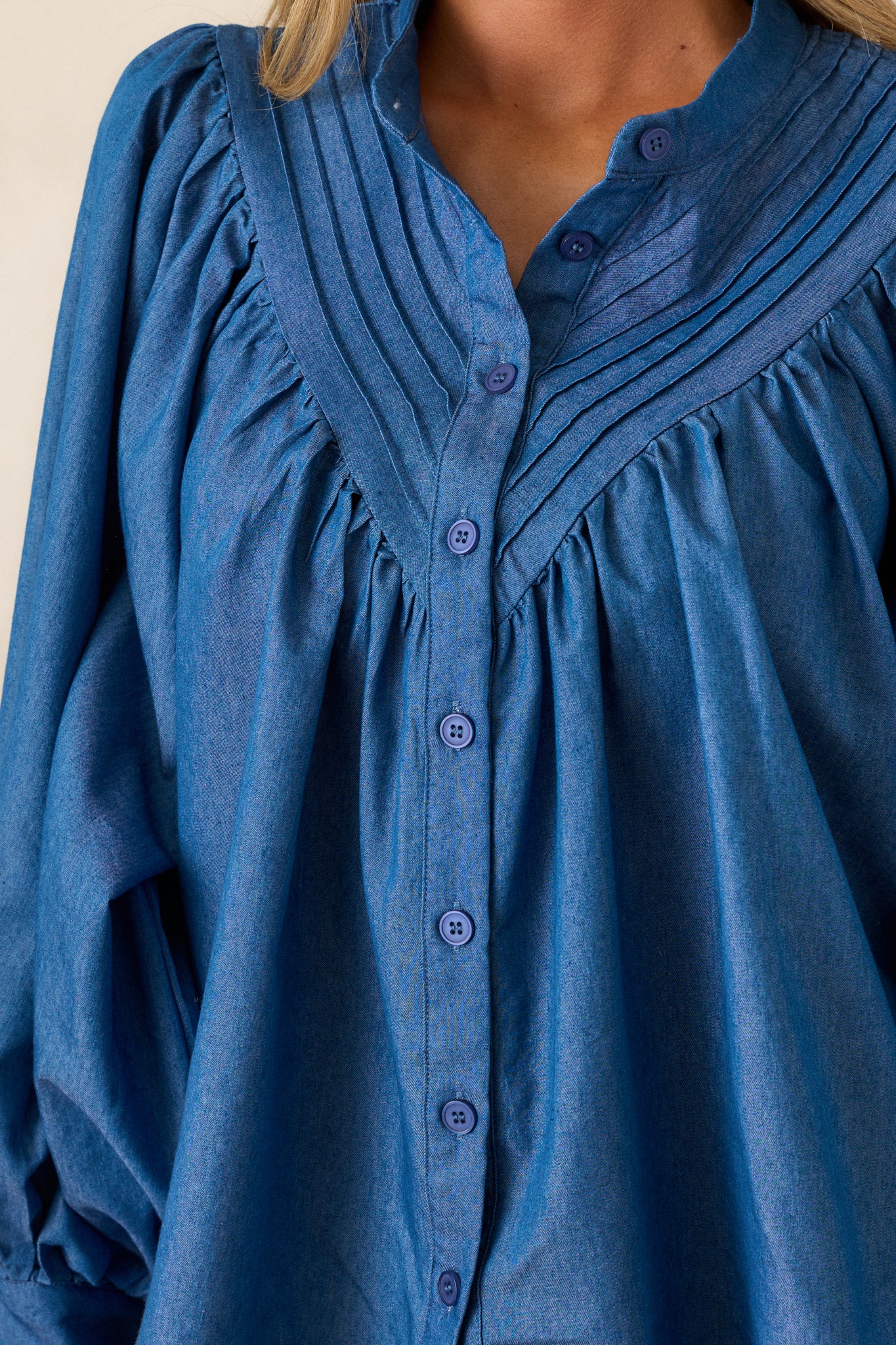 Close-up of the pleated detailing along the yoke and bust, showcasing the craftsmanship and texture that adds depth to the blouse.
