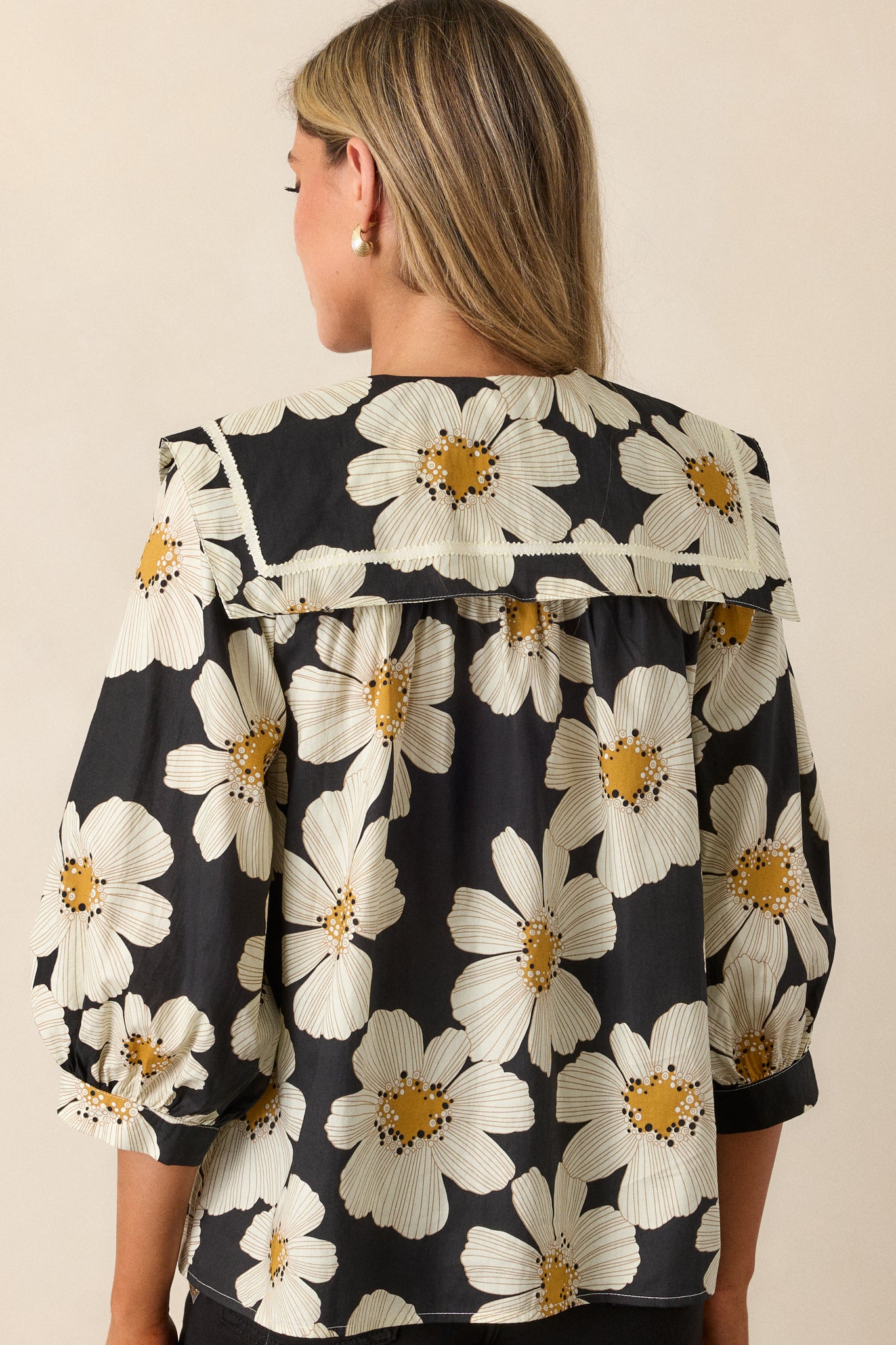 A back view of the blouse, showcasing the continuous floral print and the simple, clean look of the fabric from behind.