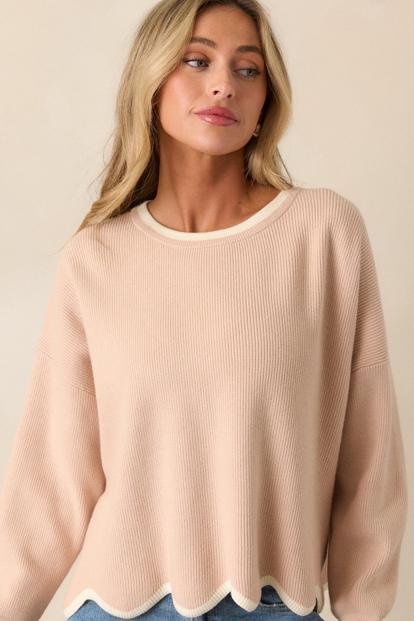 Close-up of the neckline, capturing the soft knit texture and the rounded shape, providing insight into the sweater's comfortable style.