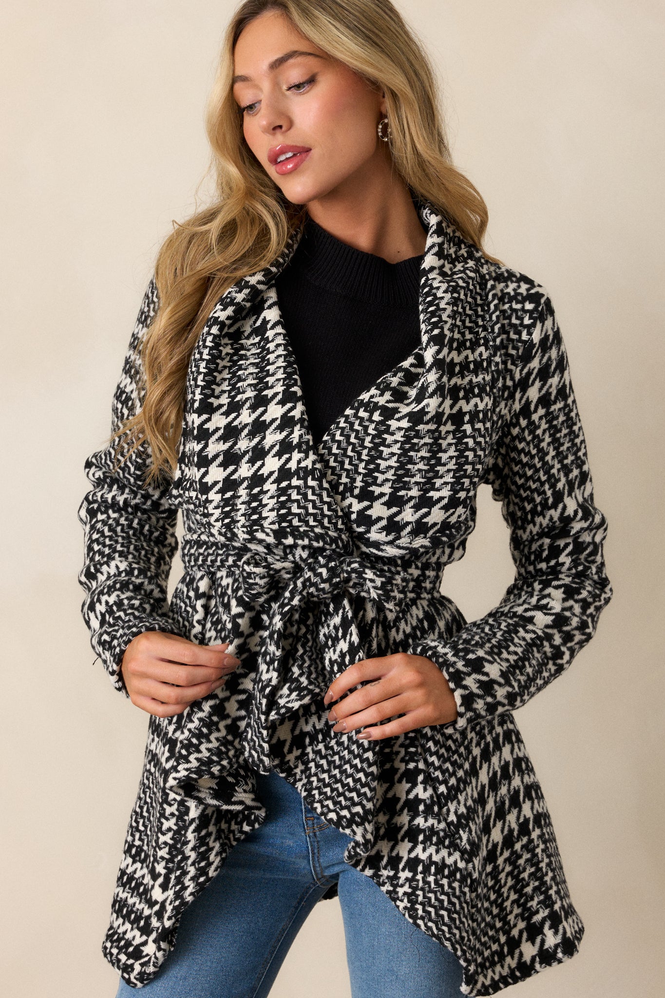 Front view of the black jacket showcasing its collared neckline and elegant white and black houndstooth pattern.