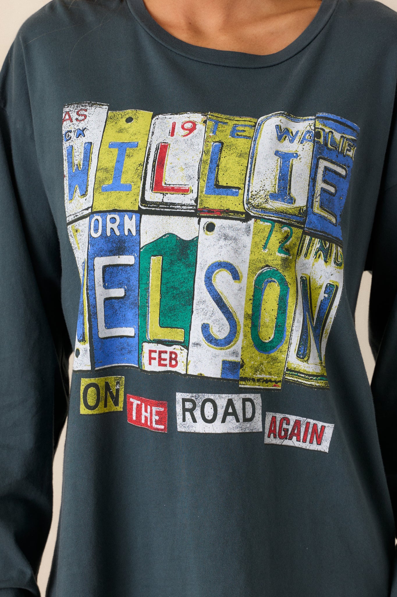 A close-up shot of the "Willie Nelson On the Road Again" graphic on the front of the tee, with clear focus on the design. The fabric texture and relaxed fit of the top are also visible.