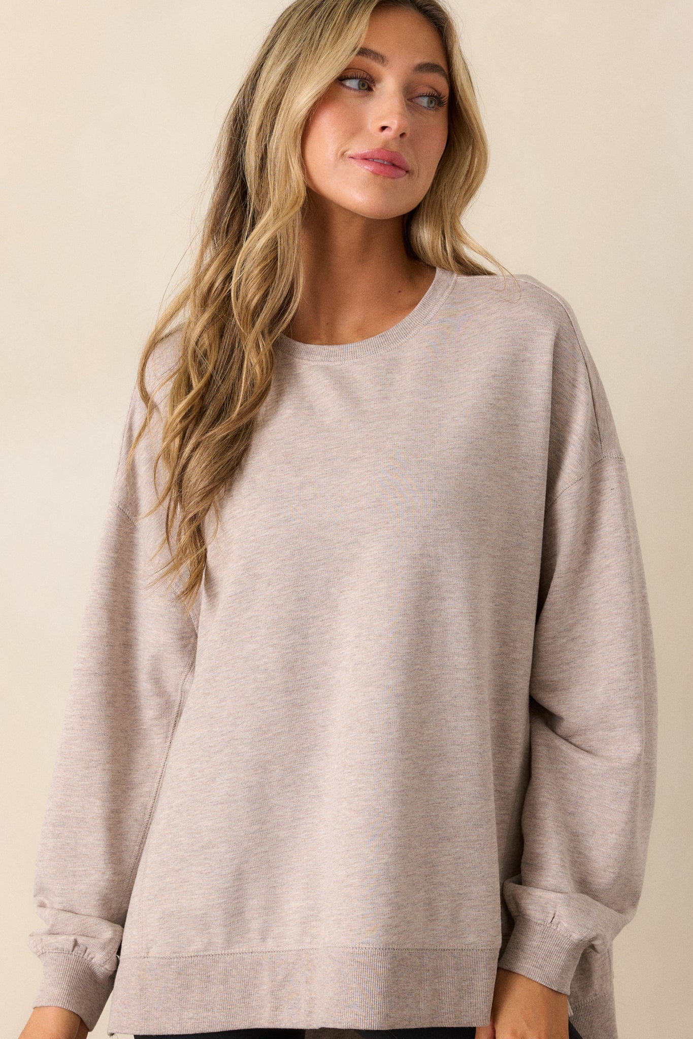 Closer look at the taupe top’s crew neckline, ribbed cuffs, and slightly oversized fit.