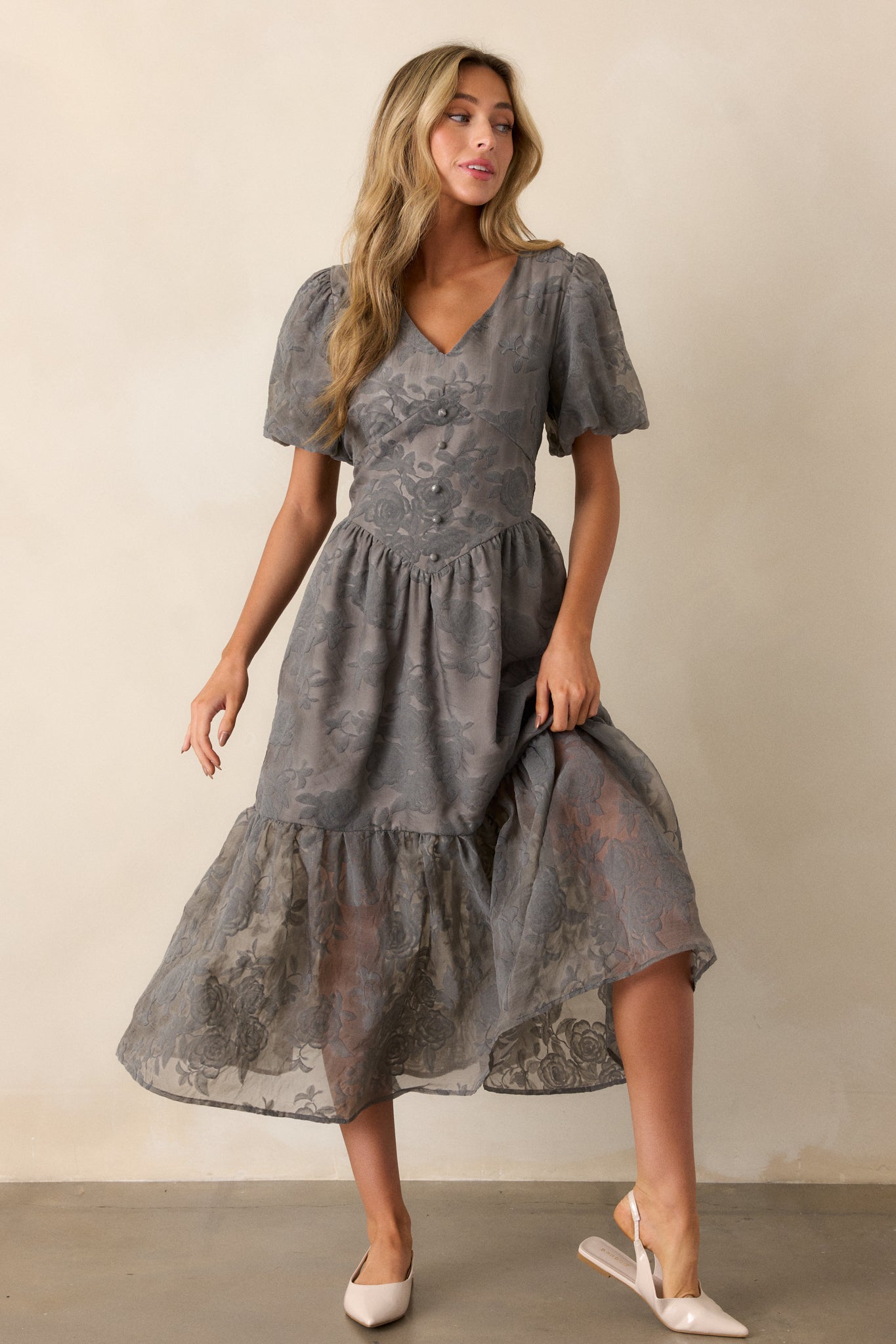 Front view of the grey floral dress, highlighting the v-neckline and faux corset waist with button detailing.