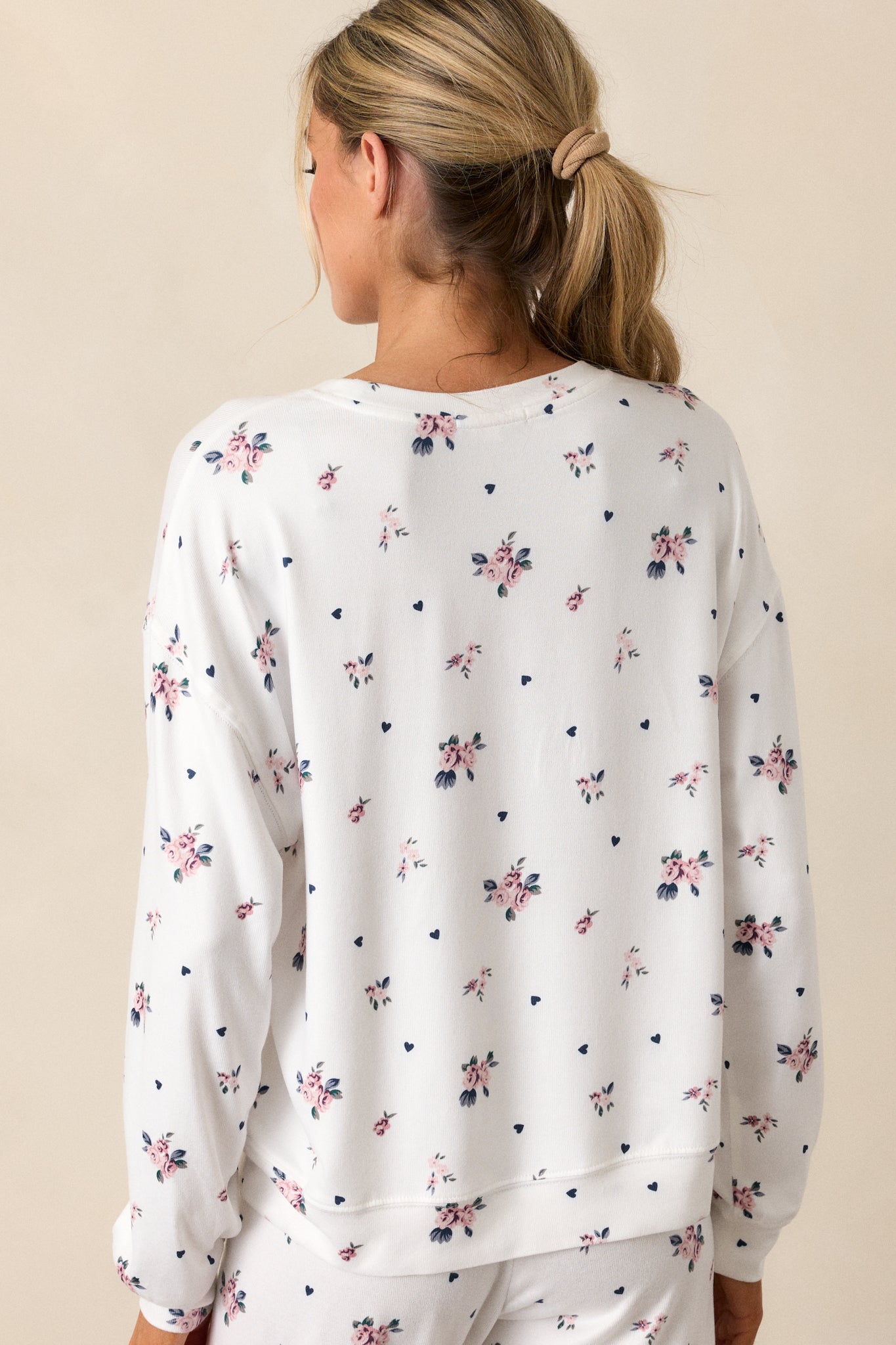 A back view of the ivory top, emphasizing the relaxed fit and the long sleeves. The rosebud pattern continues on the back, maintaining a cohesive and feminine look.