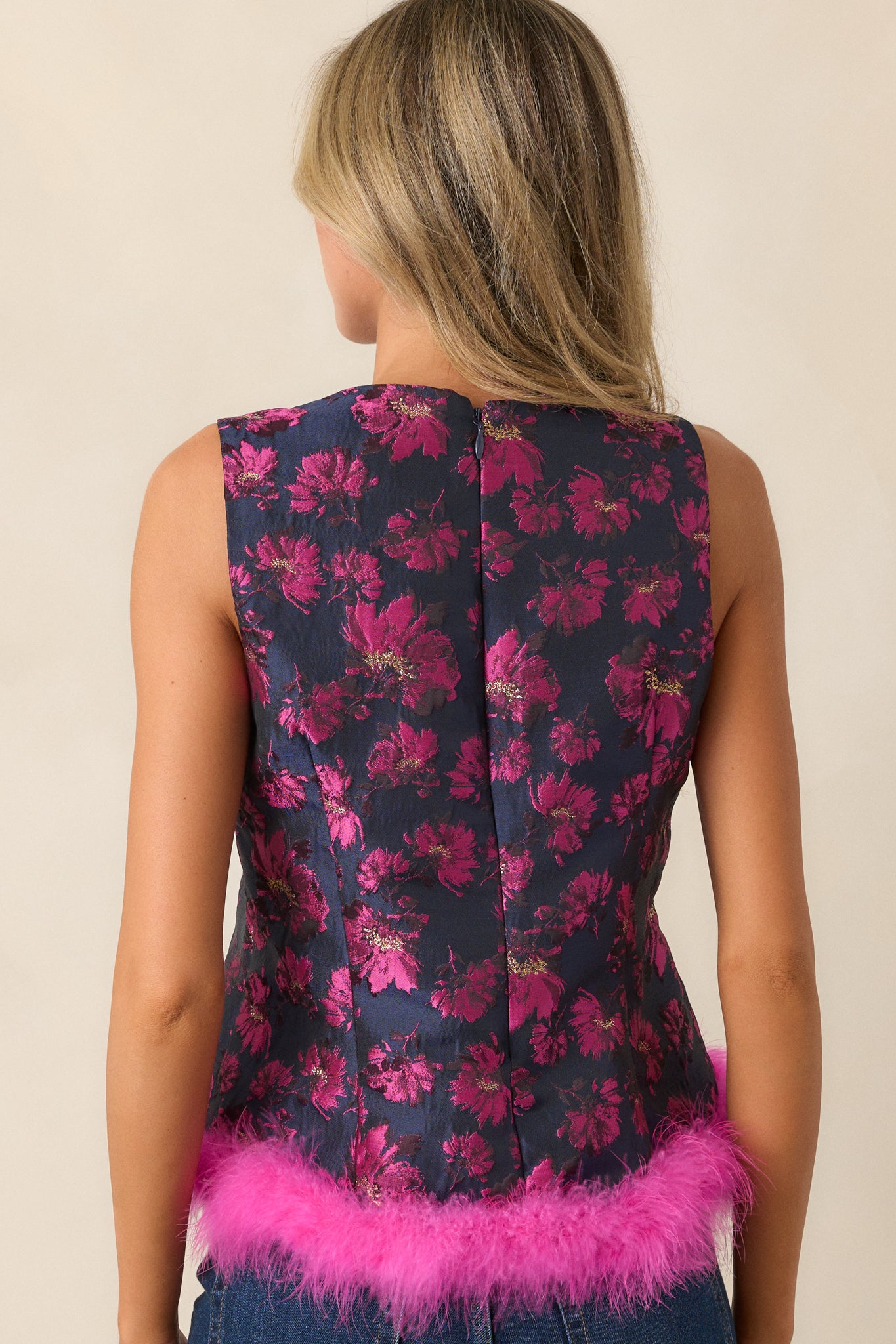 A back view of the top, showcasing the discrete back zipper and the structured fit of the peplum design.