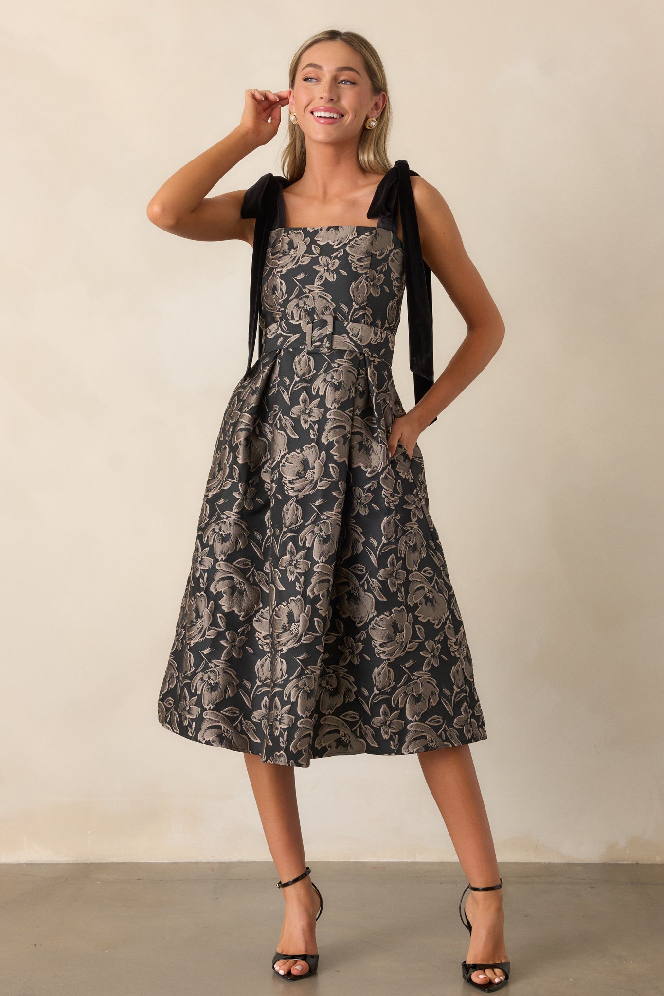 A full-body view of the dress emphasizing the structured fit, jacquard fabric, and the self-tie velvet bows on the shoulder straps.