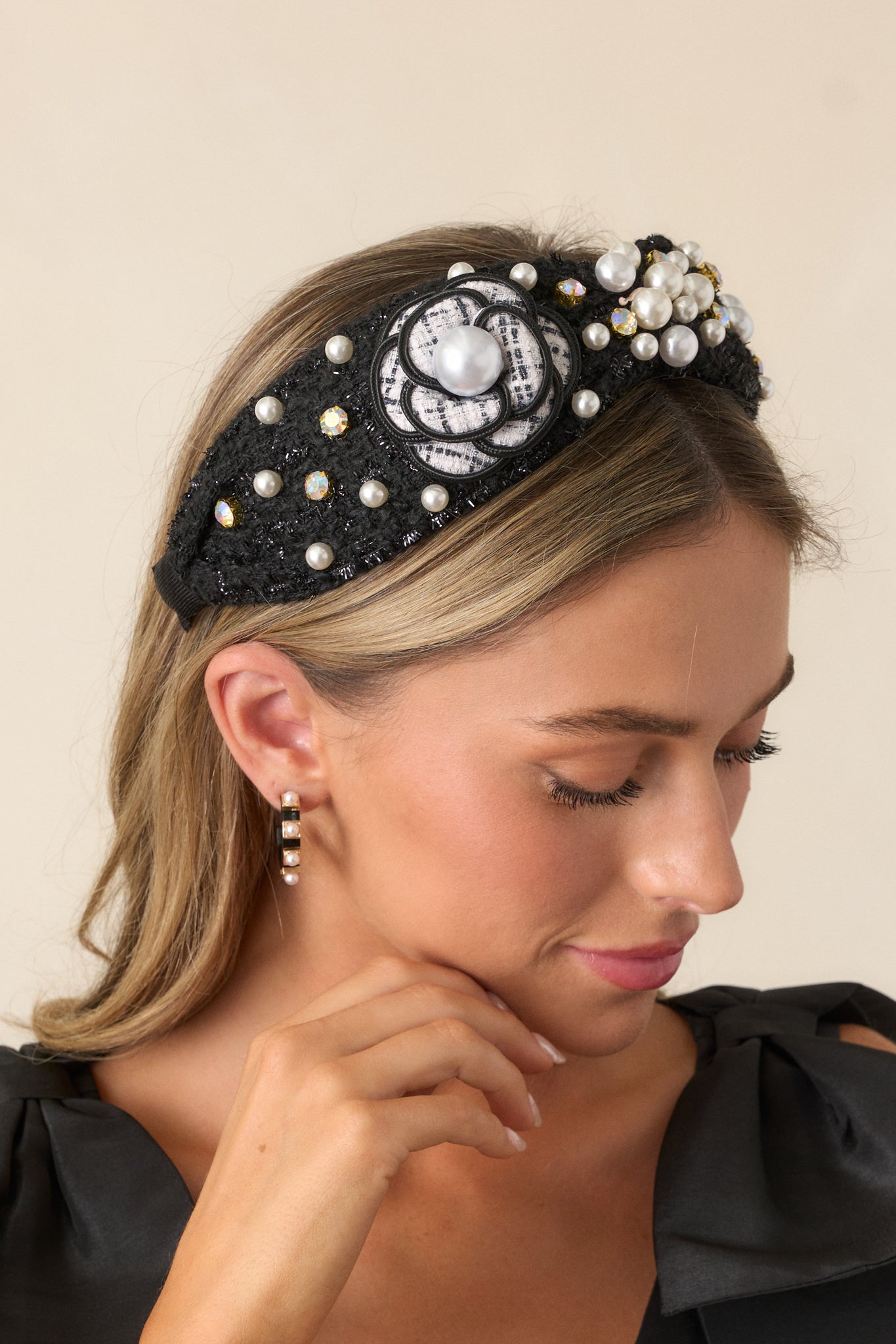 Top-down view of the black tweed headband worn, emphasizing the tweed flower detail and shimmering embellishments.