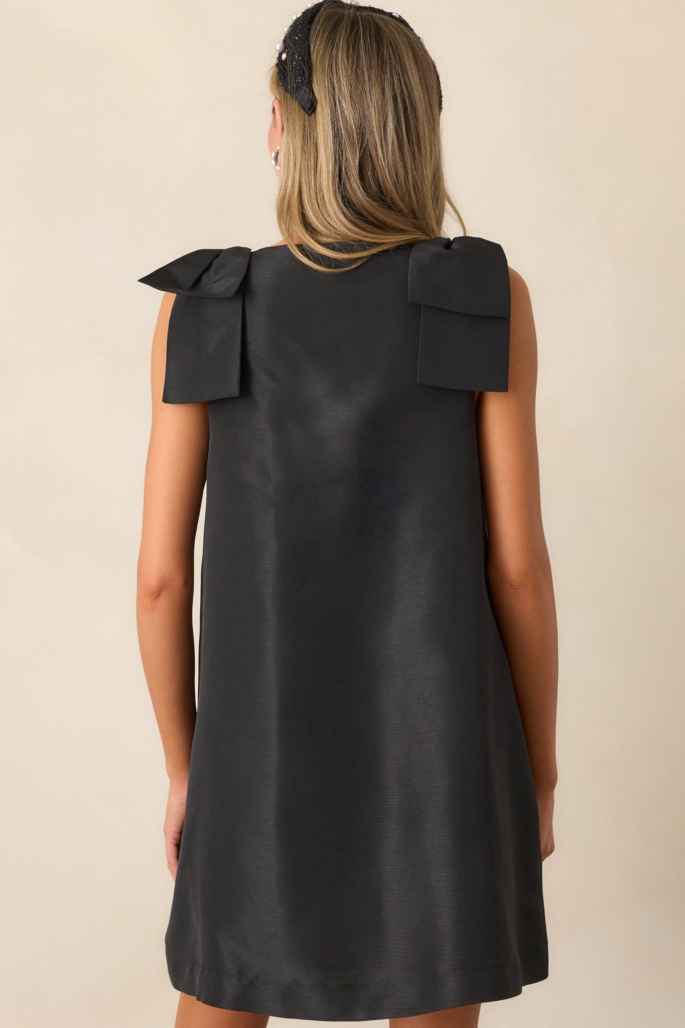 Back view of the dress, showing the relaxed fit and the smooth, clean lines of the dress with the bows on each shoulder as the focal point of the design.