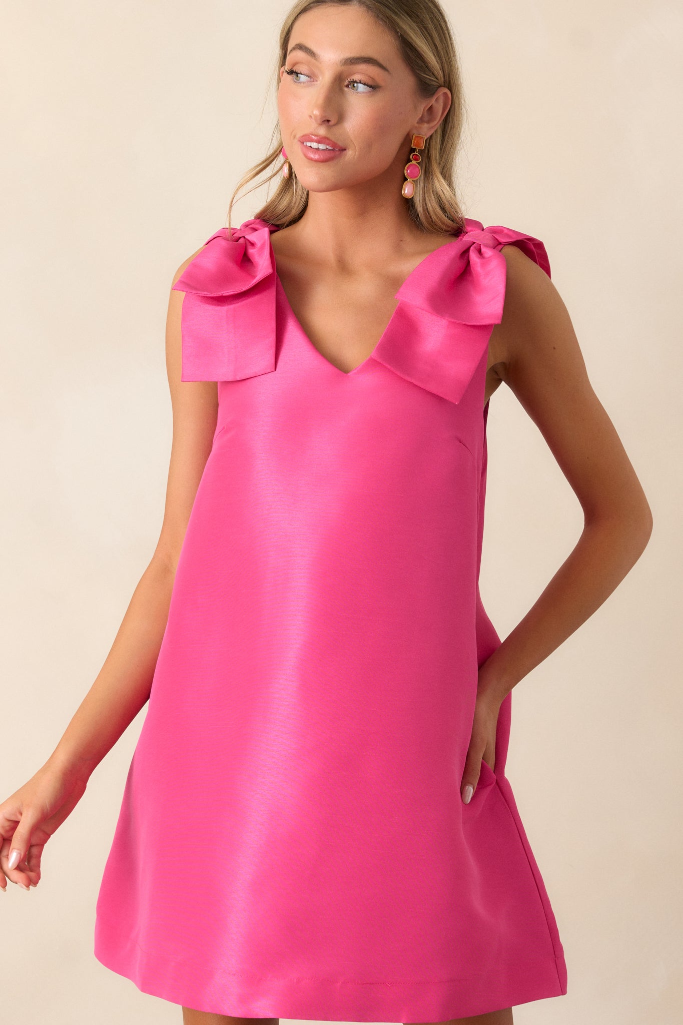 Front-facing view of the fuchsia mini dress, featuring the vibrant color, relaxed fit, and bow detailing on both shoulders for a delicate, feminine look.