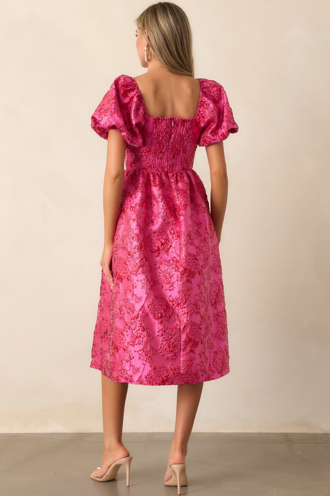 Back view of the pink dress, showcasing the smocked back panel and the hidden back zipper closure.