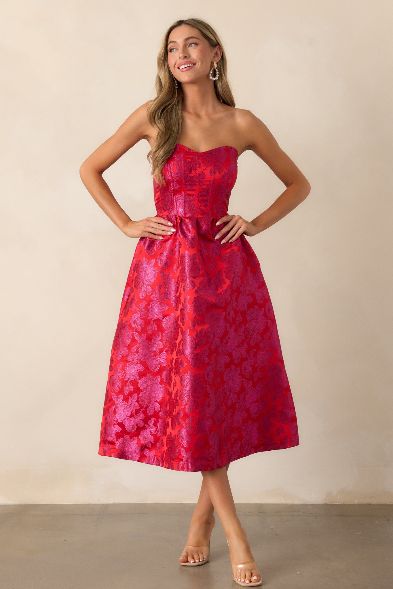 Front view of the red and pink midi dress showcasing the strapless sweetheart neckline and floral jacquard fabric, with structured boning visible in the front bodice.