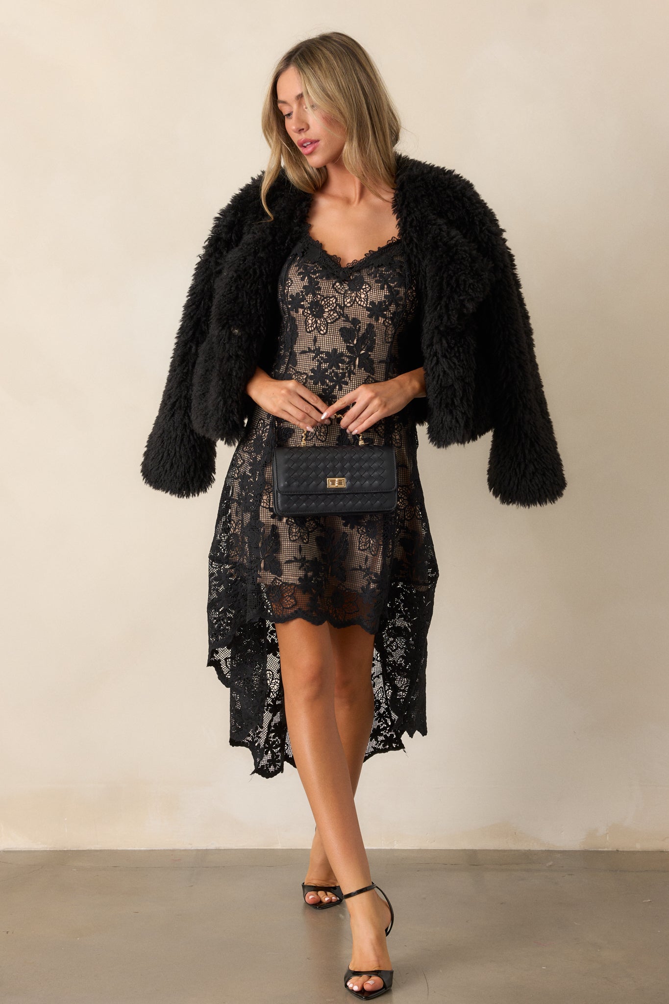 Full-length view of the plush faux fur jacket, featuring elastic cuffs and a cozy rounded neckline, styled with its asymmetrical front snap closure.