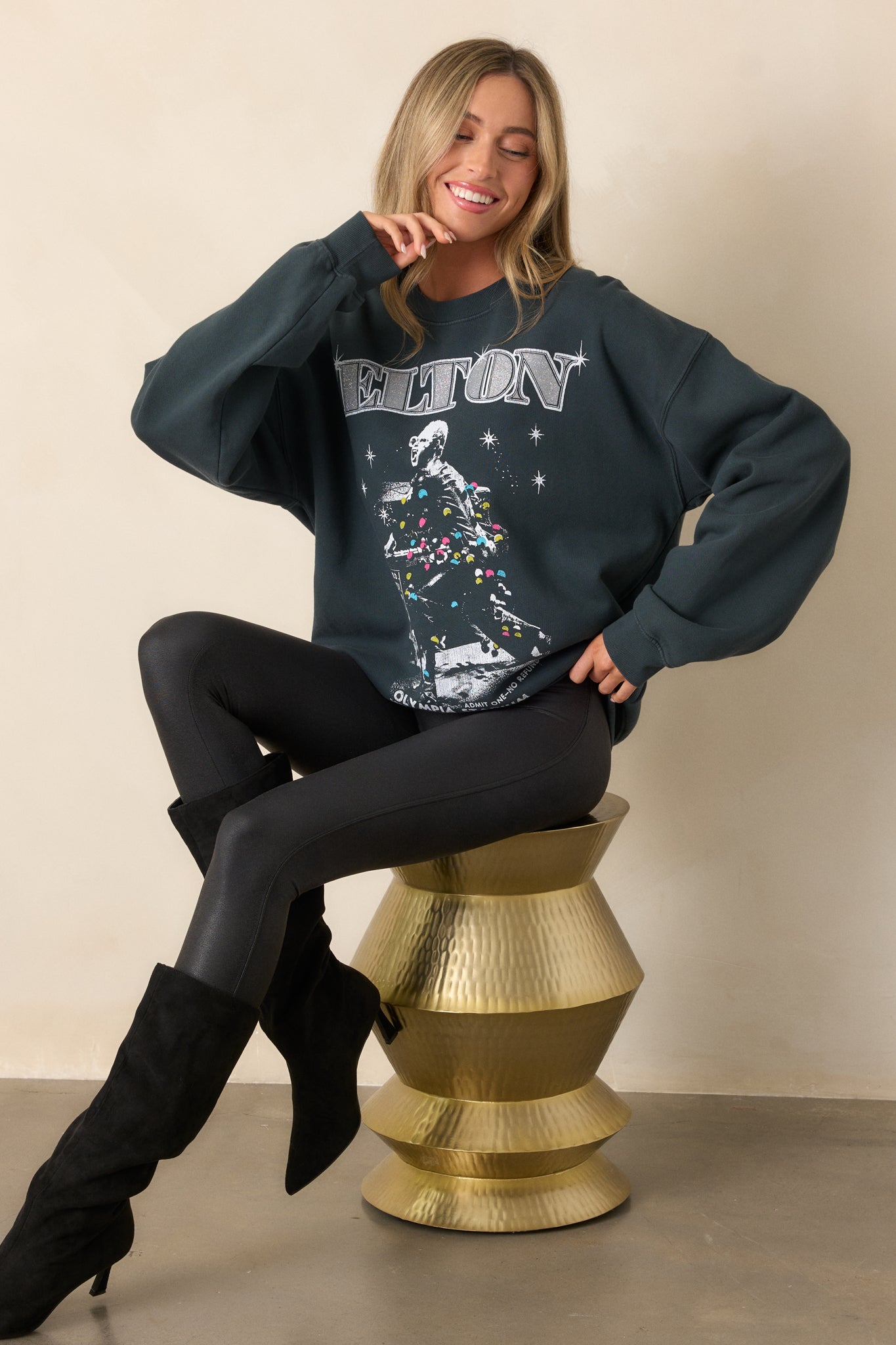 Front view of the charcoal sweatshirt with a crew neckline and relaxed fit, showcasing the "Elton John Olympia Stadium" graphic.