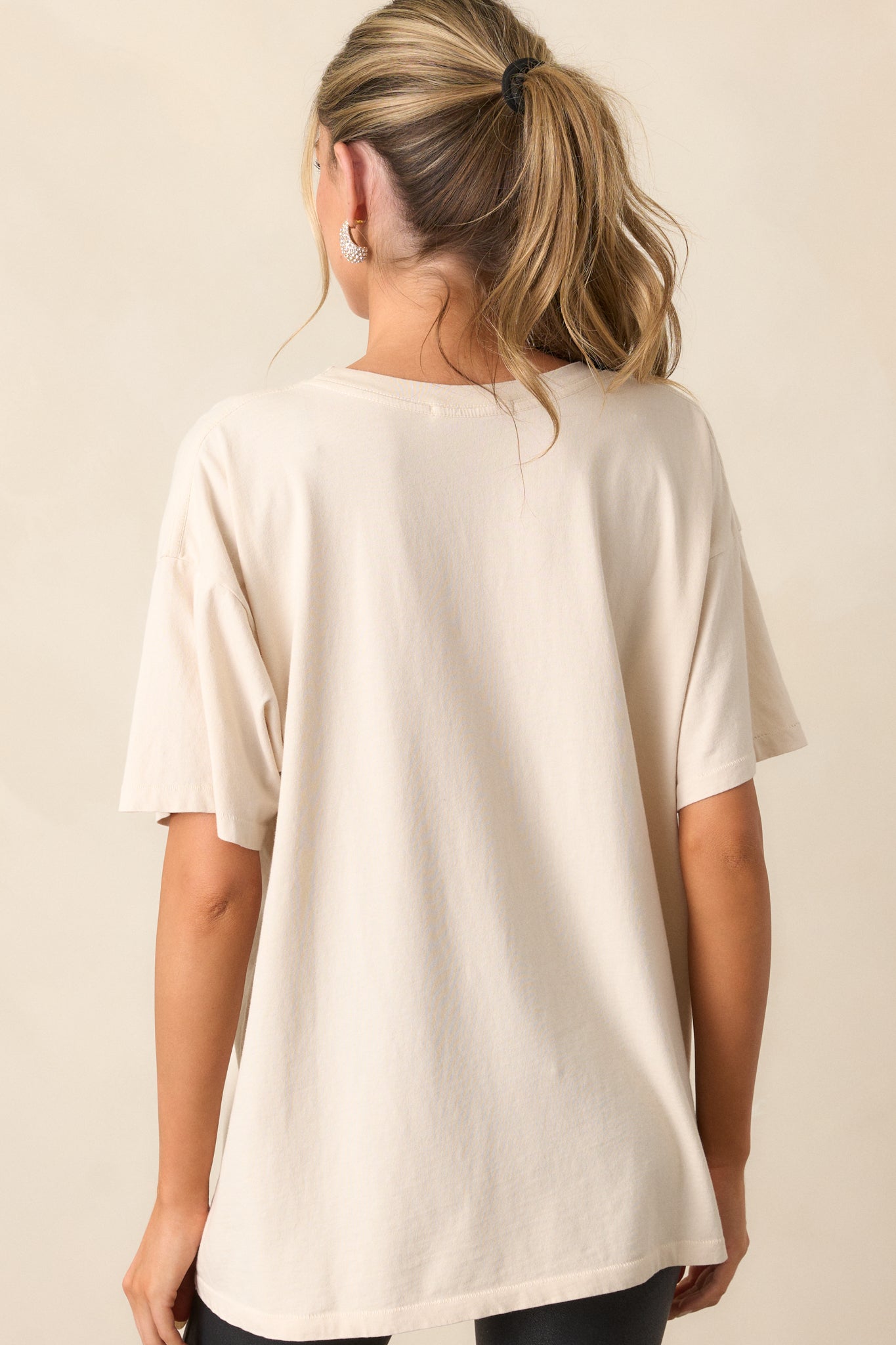 The back view of the ivory tee, featuring a plain design with smooth fabric and no graphics or embellishments.