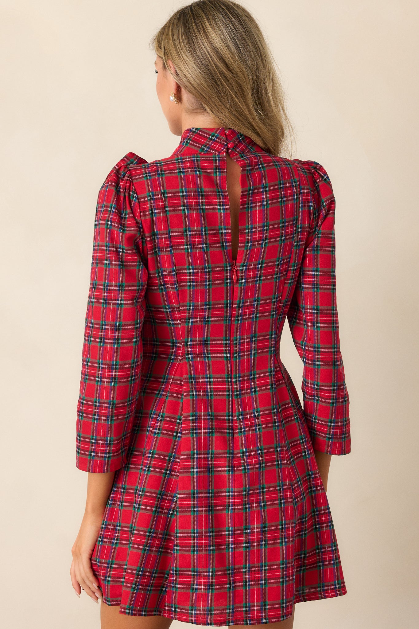 Back view of the red mini dress, highlighting the discrete back zipper, the fit and flare design, and the plaid pattern.